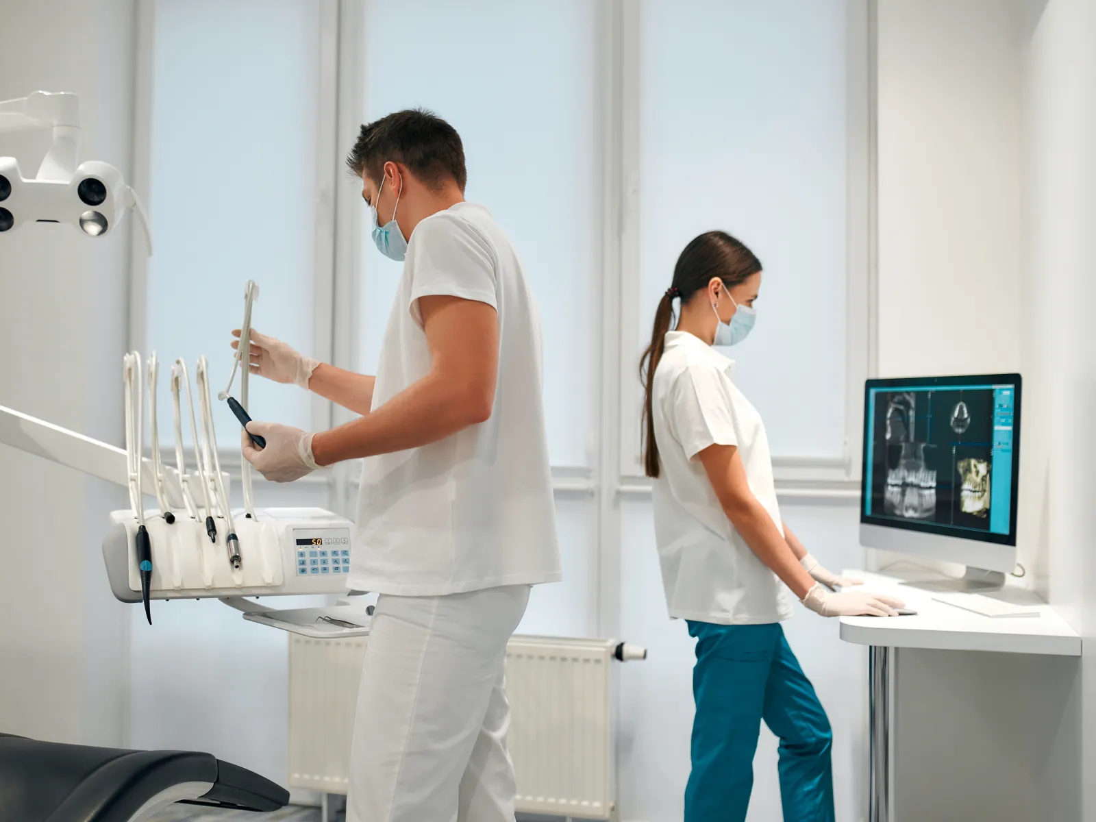 a man and a woman in a room with a computer and a monitor