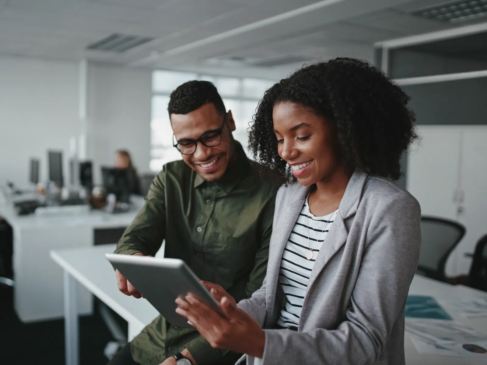 a man and a woman looking at a tablet