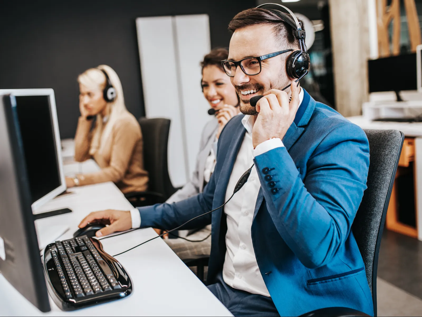 a person wearing headphones and sitting at a computer