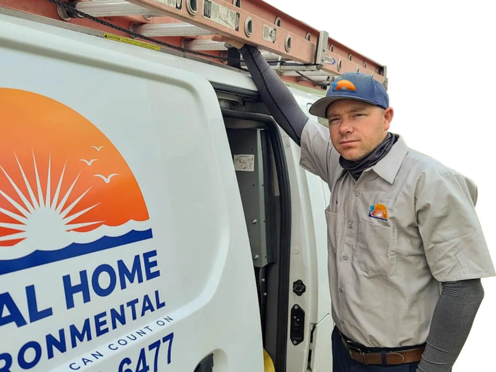 Technician leaning on a Total Home Environmental service van with company logo and ladder on top