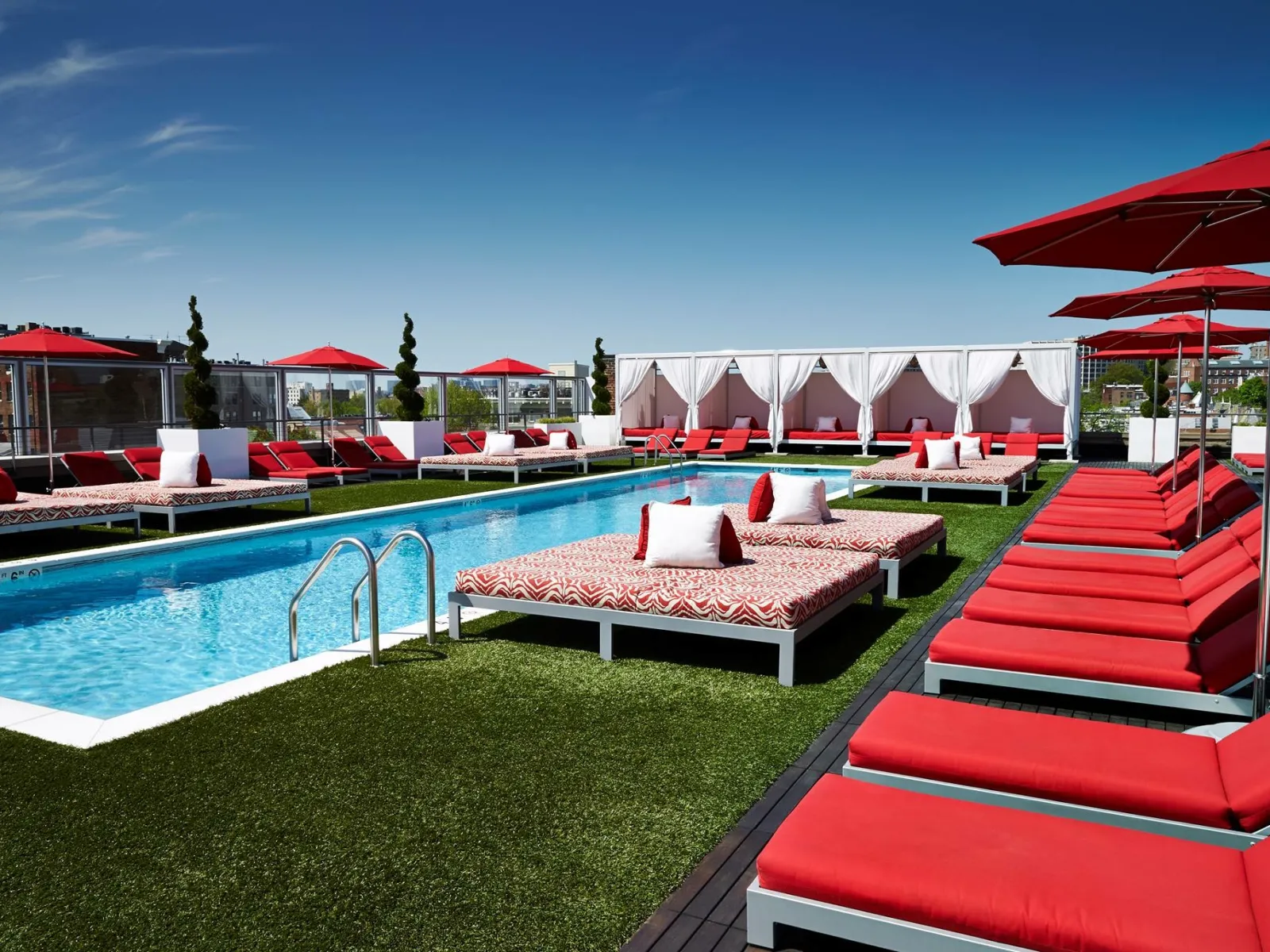 a pool with lounge chairs and umbrellas by it