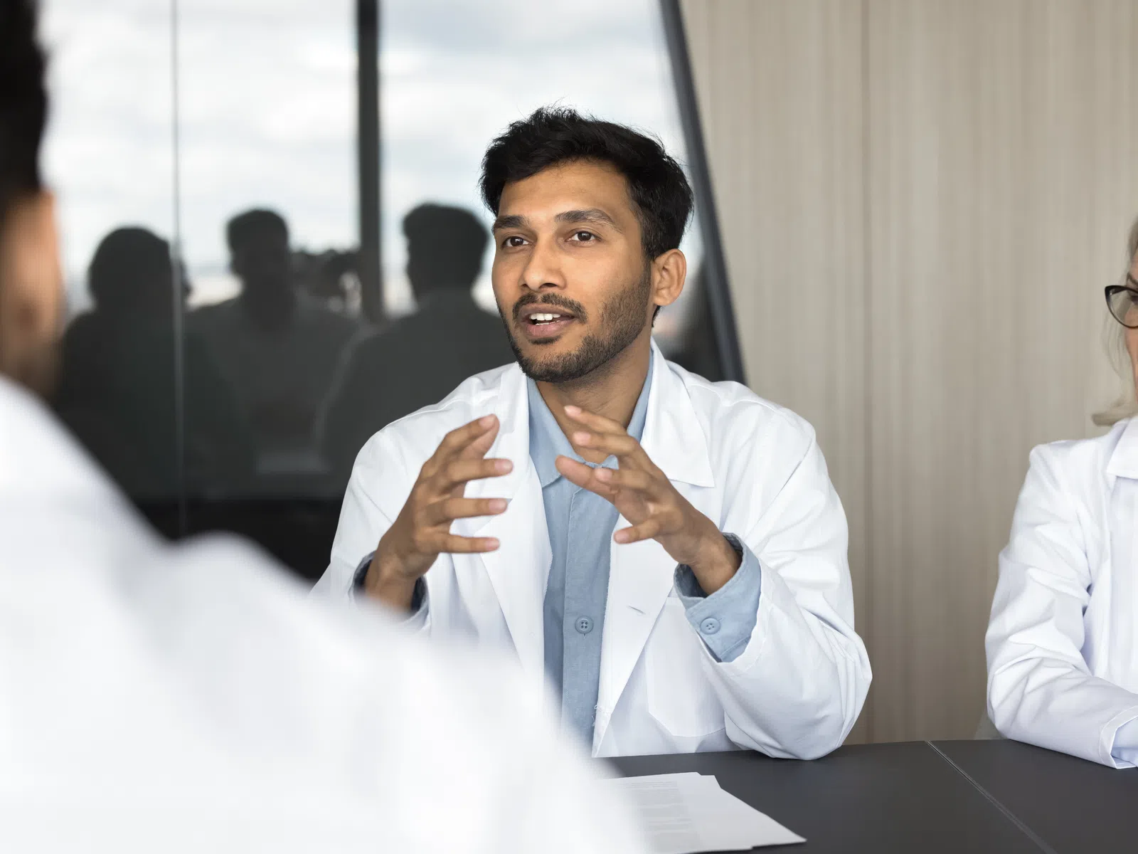 Male doctor explaining a concept to colleagues during a medical meeting in a conference room