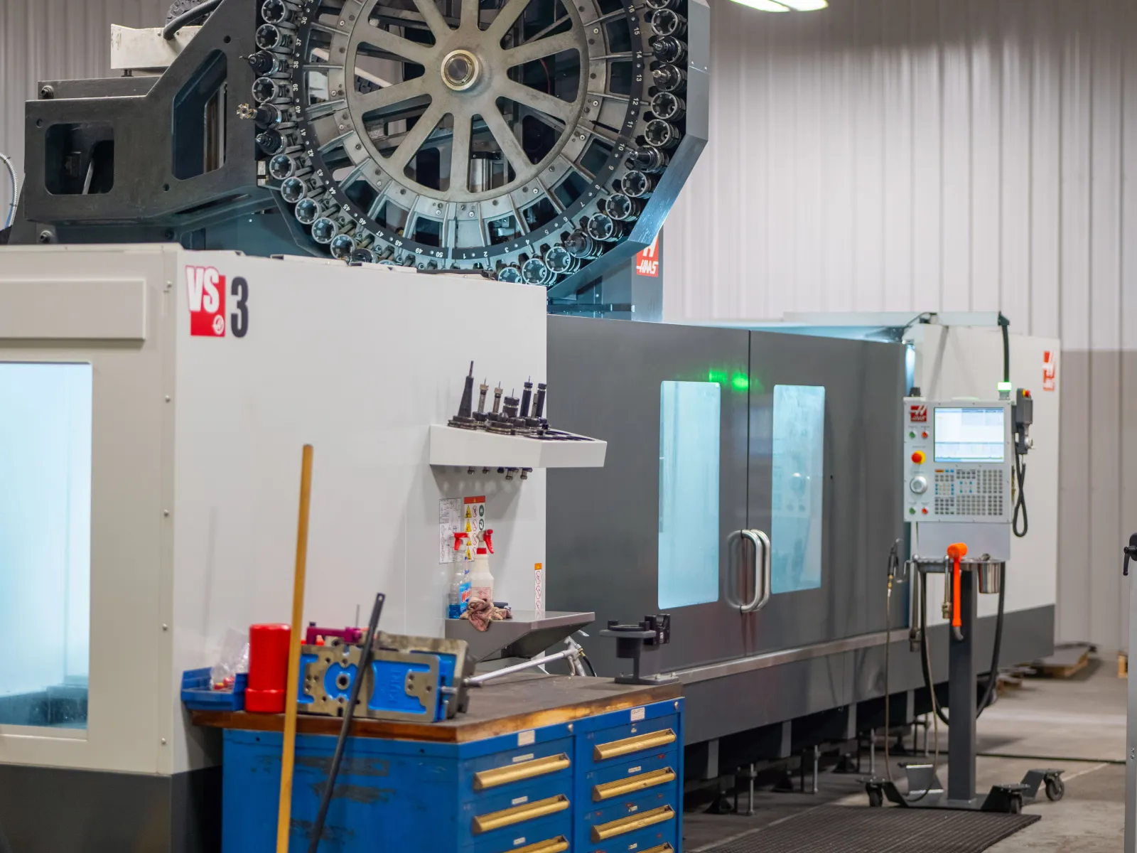Industrial CNC machining center with tool carousel and control panel in manufacturing workshop environment