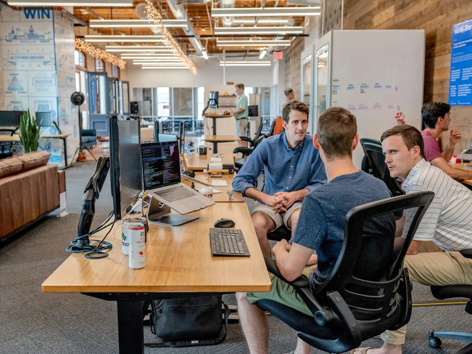 a group of people sitting at a table with computers