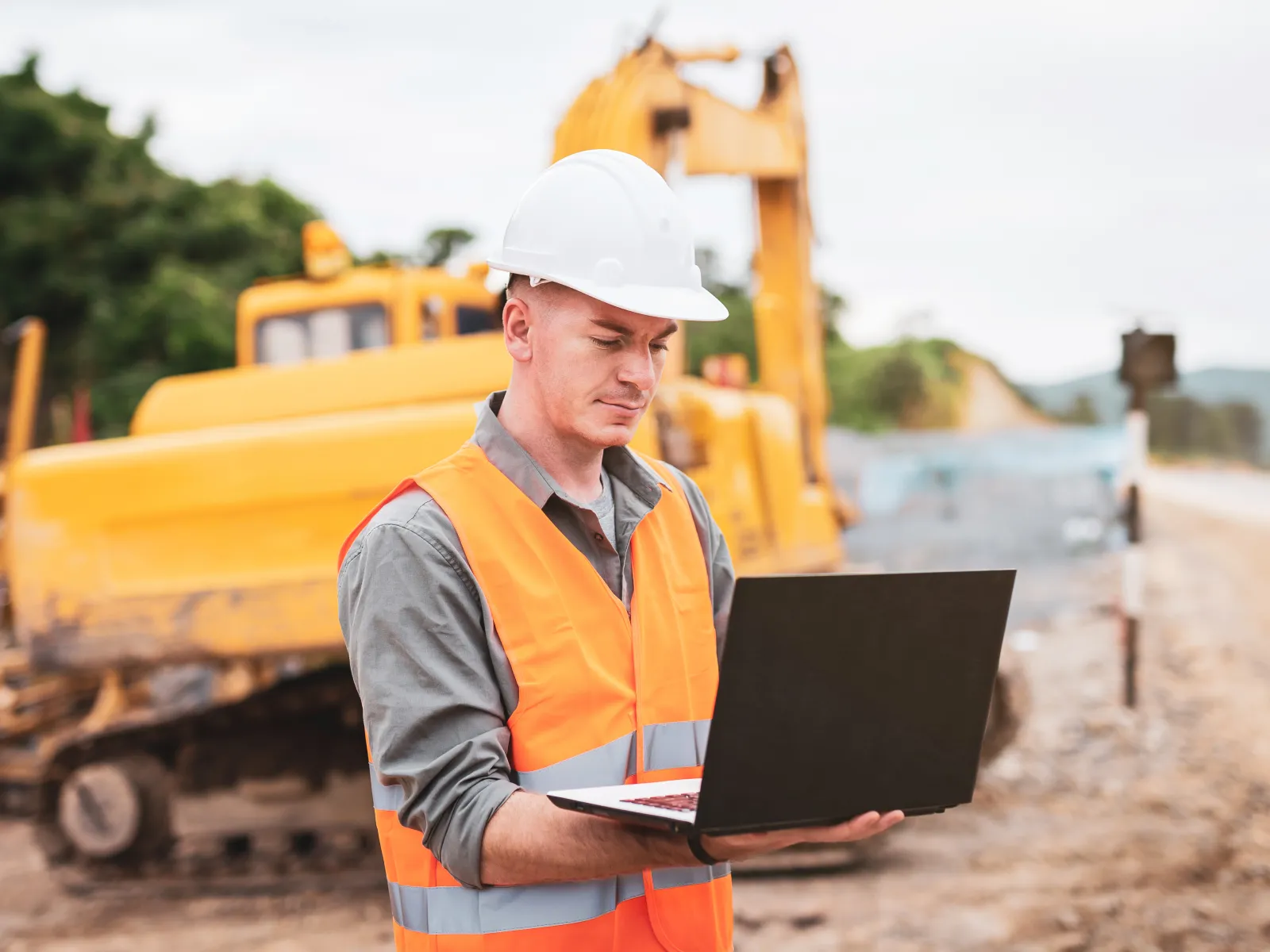 a man in a hard hat working on a laptop