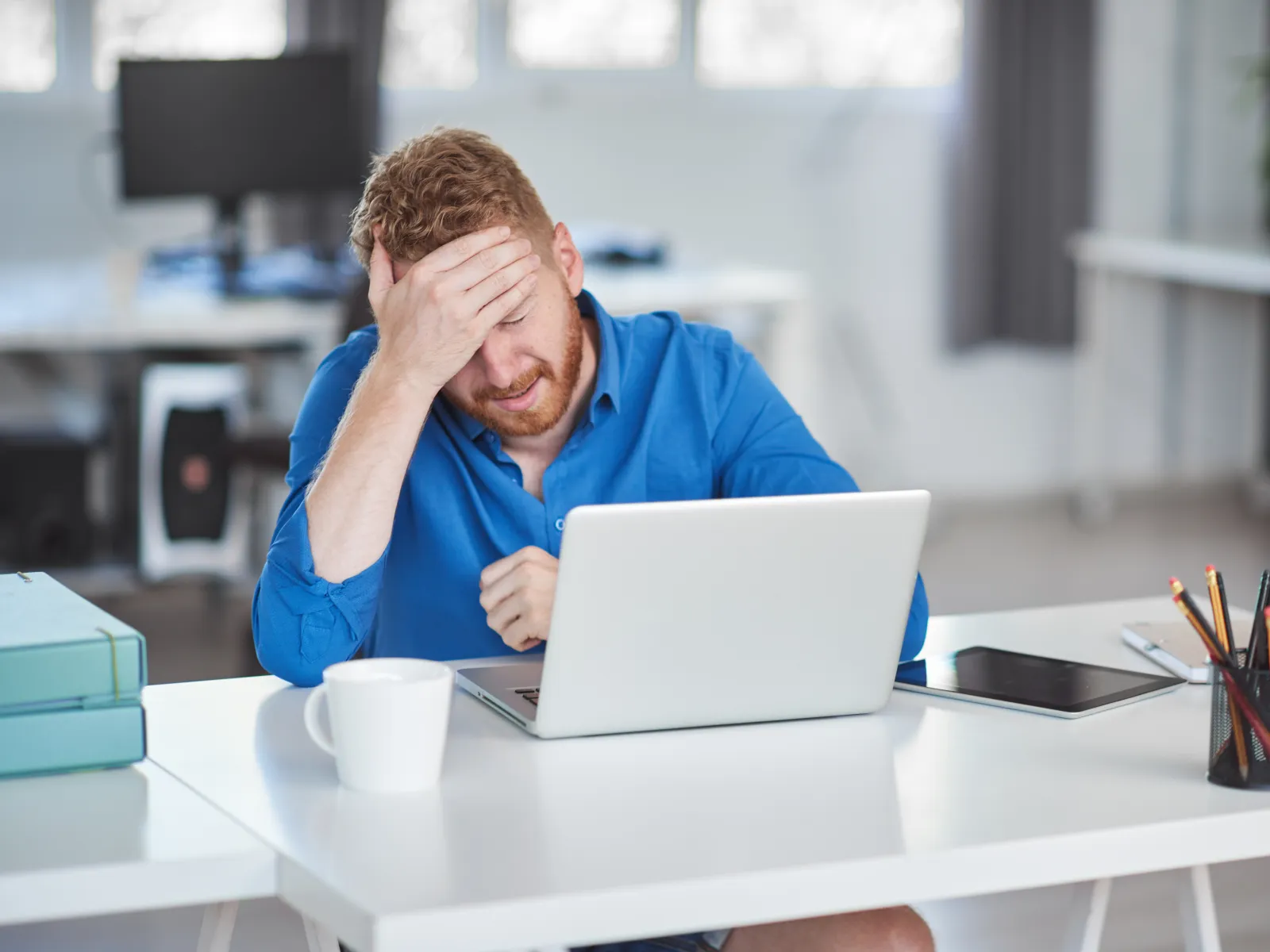 a person sitting at a table with the head on the hand