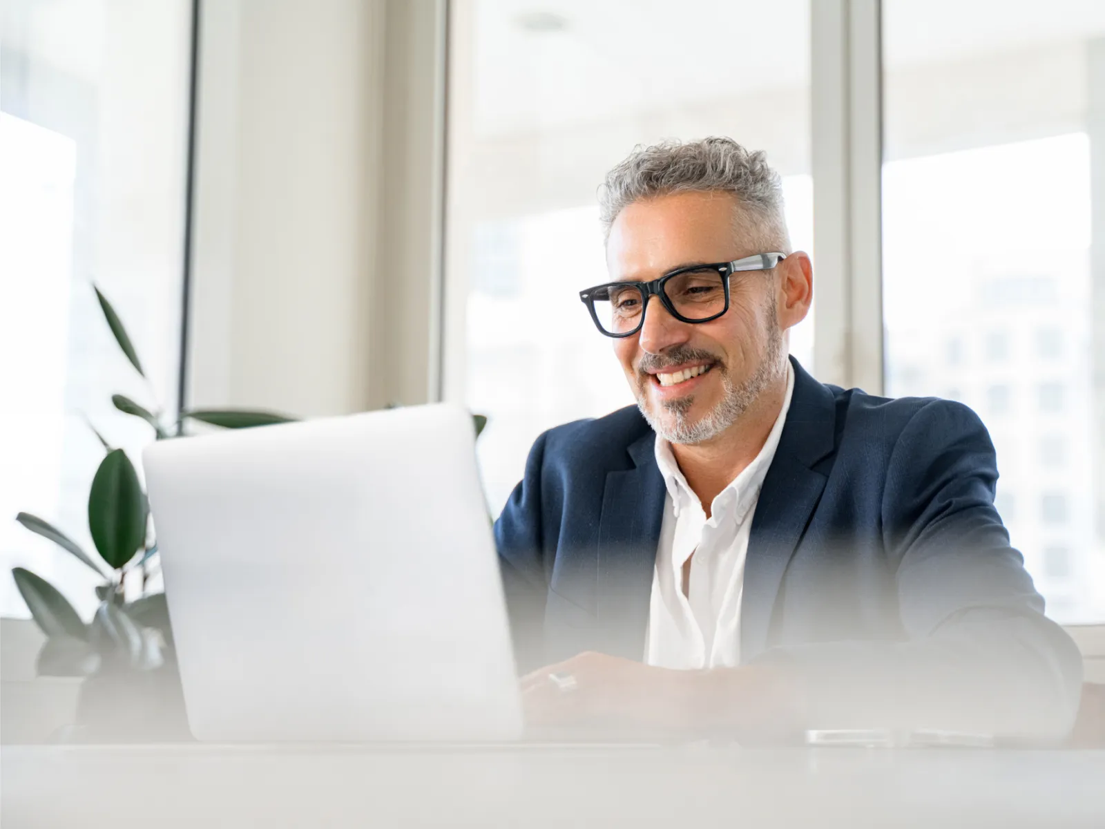 a man sitting at a desk with a laptop