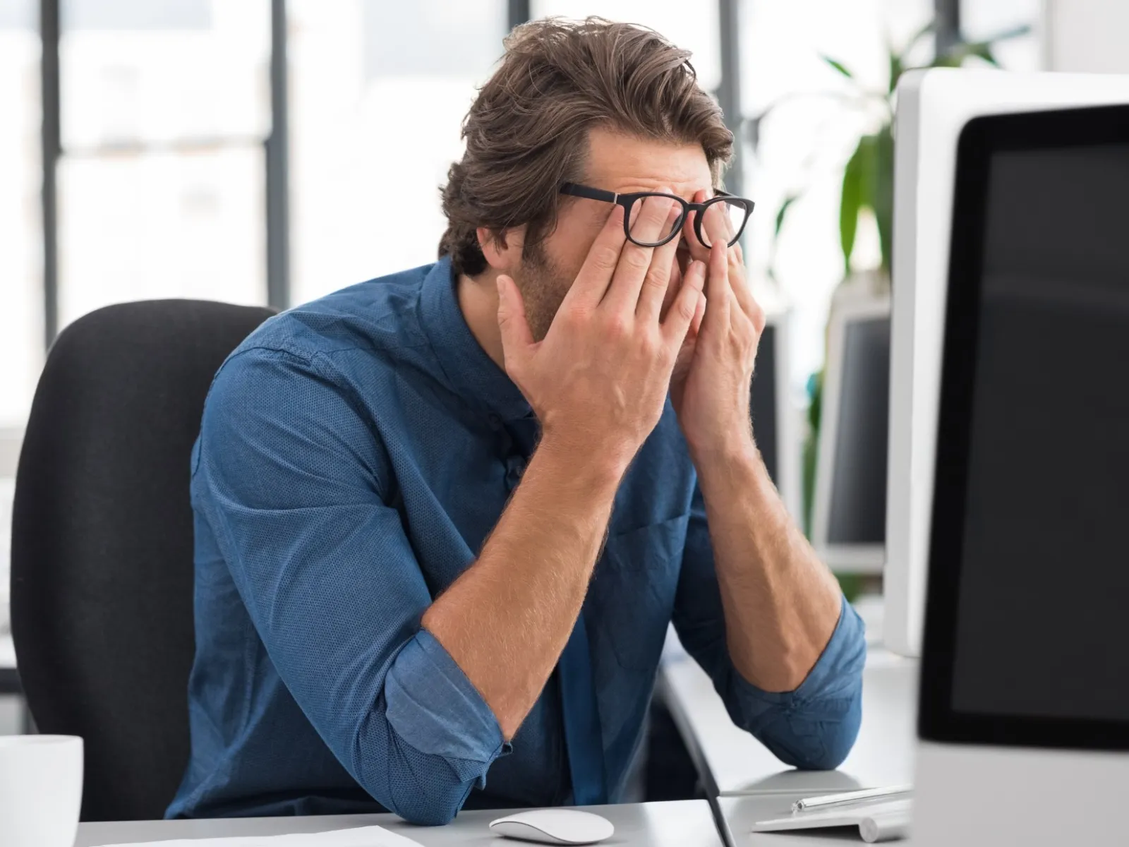 a person sitting at a desk with the hands to the face