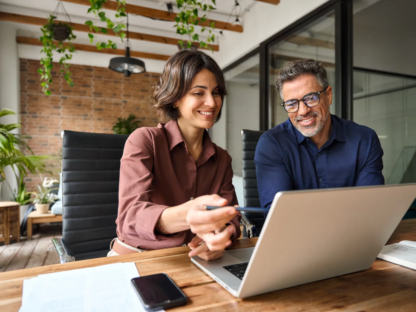 a man and a woman looking at a laptop