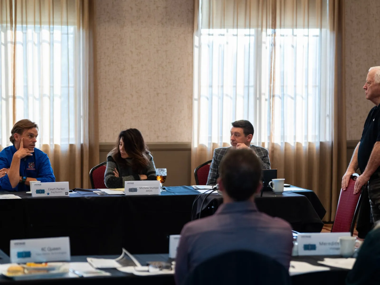 Business meeting with group discussing ideas in conference room with natural light from windows.