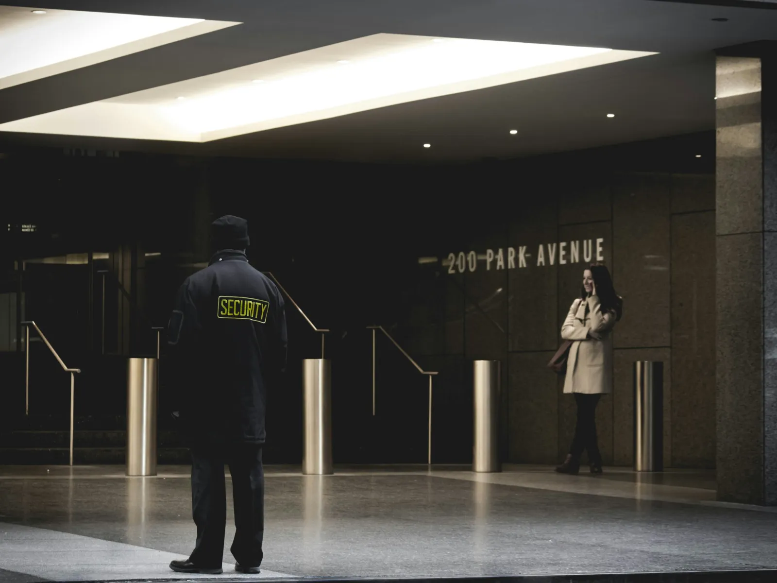 a man and woman standing in a large room with a sign on the wall