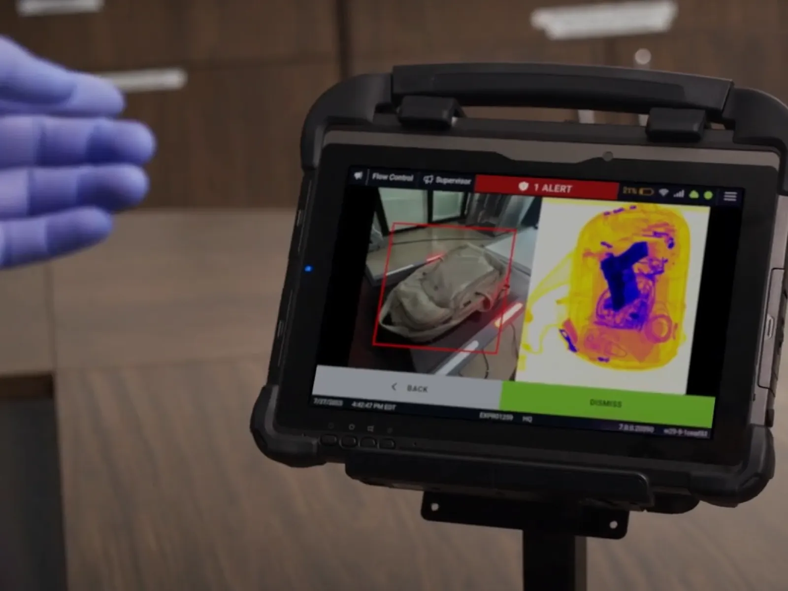 Portable security scanner displaying an alert with bag X-ray and thermal images on a tablet screen.