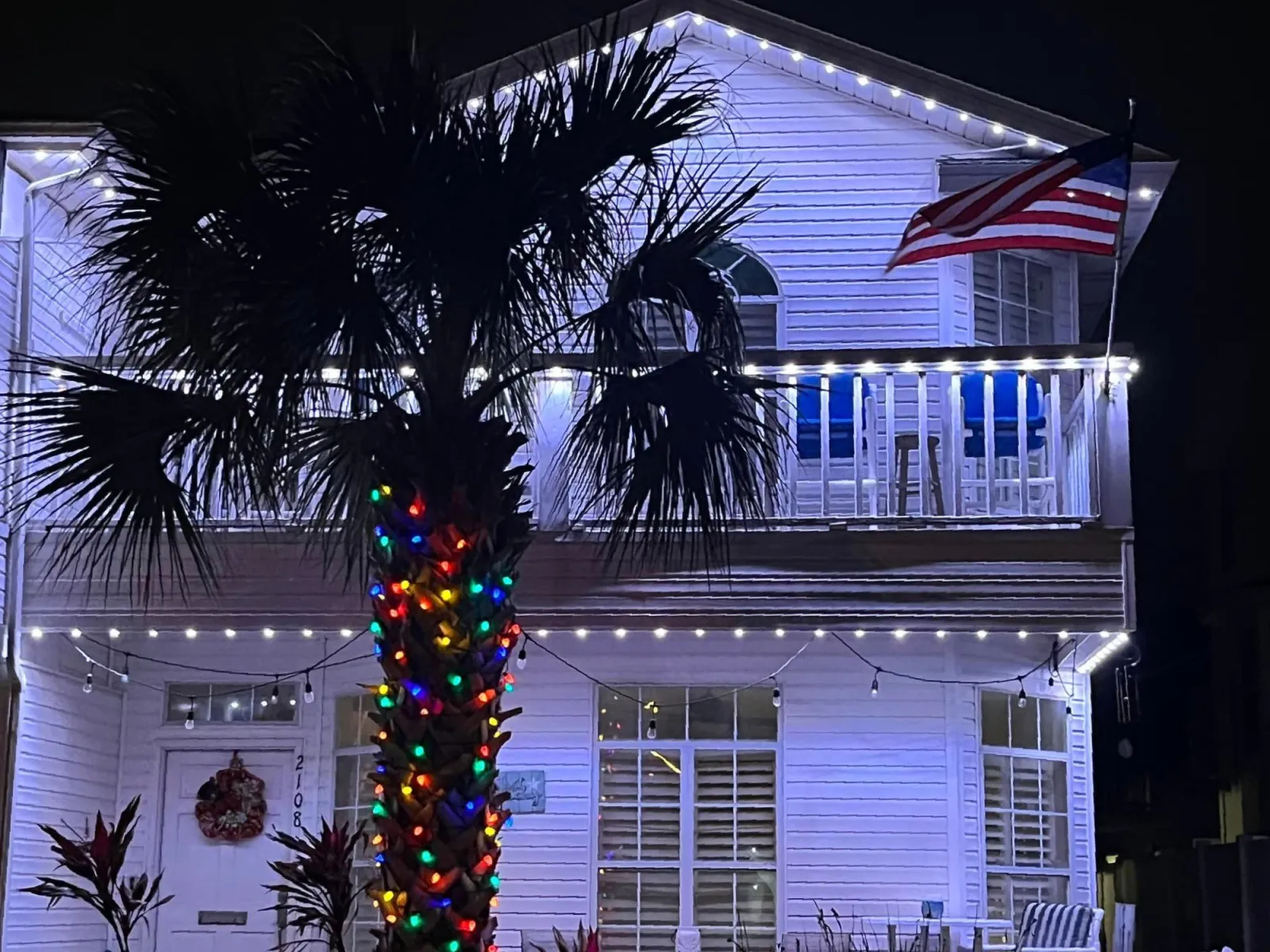 a tree with lights and ornaments in front of a building
