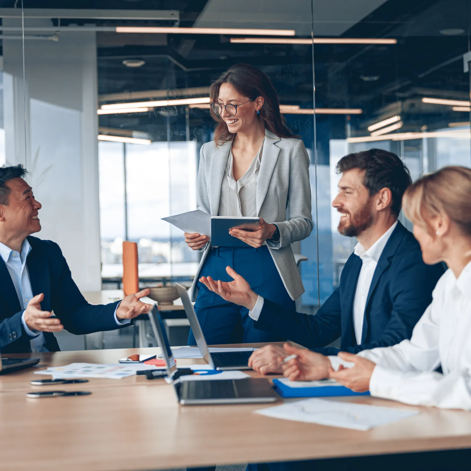 A diverse business team collaborating in a modern office setting during a meeting.