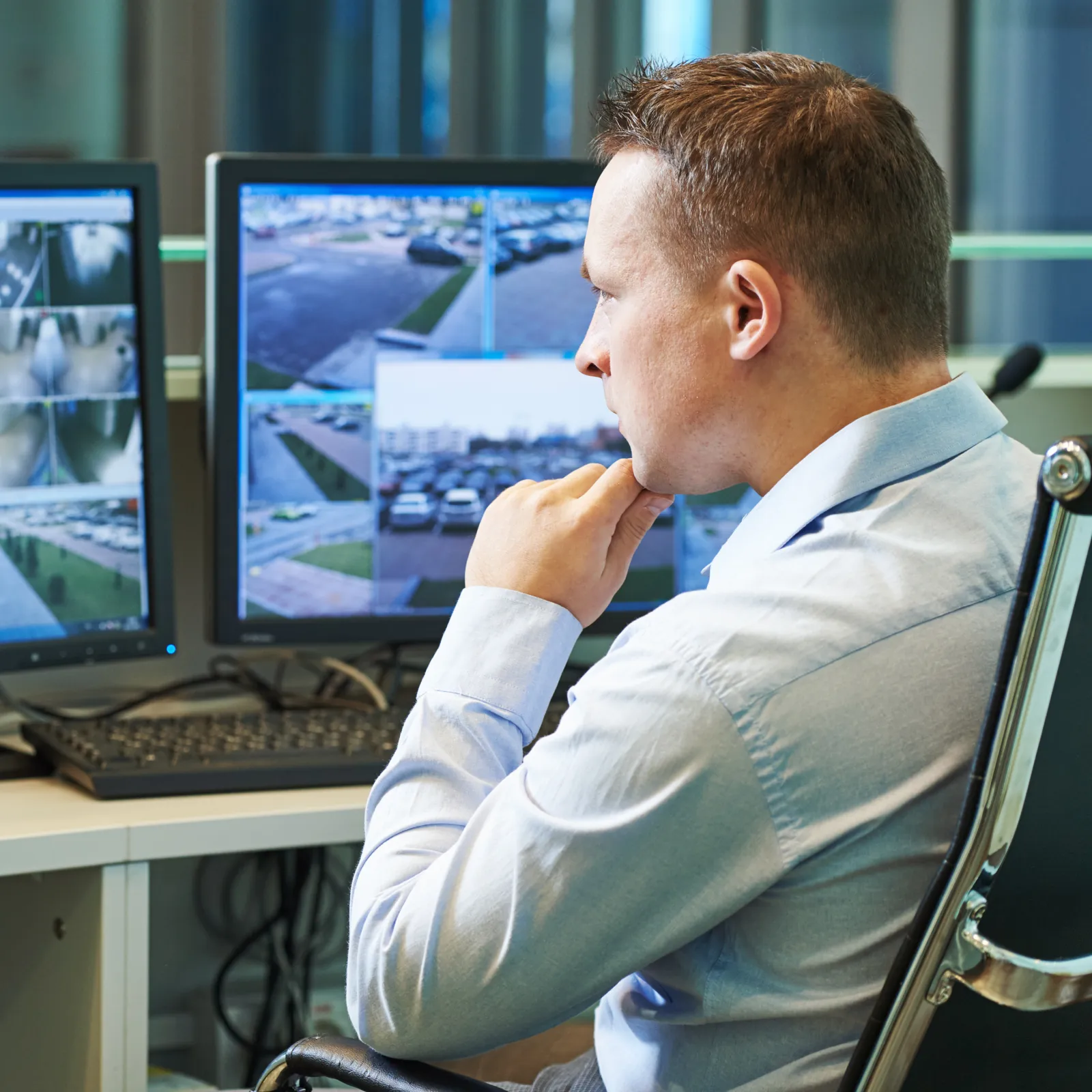 a man sitting at a desk looking at a computer screen