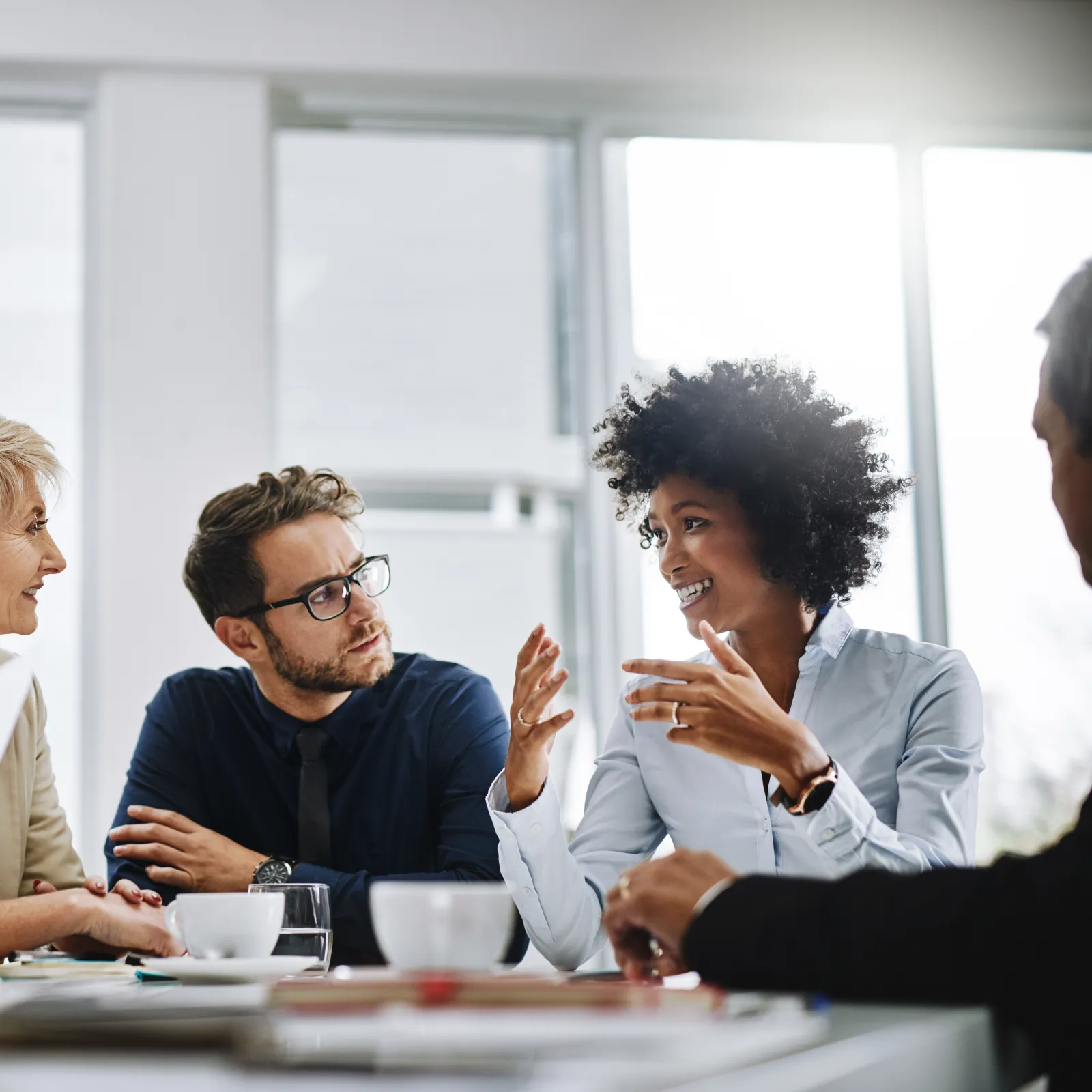 Diverse team collaborating in a modern office during a business meeting focused on discussion.