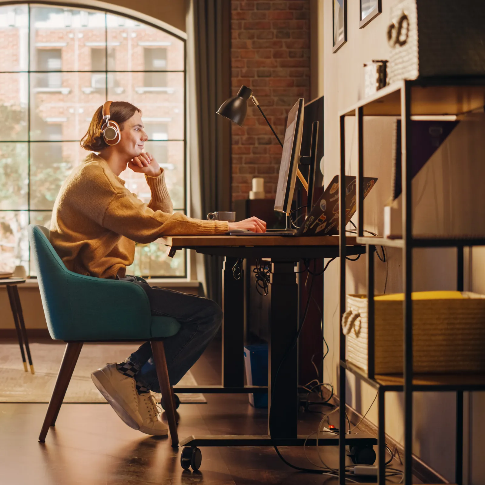 Young woman working on computer at home office with bright natural light and modern decor.