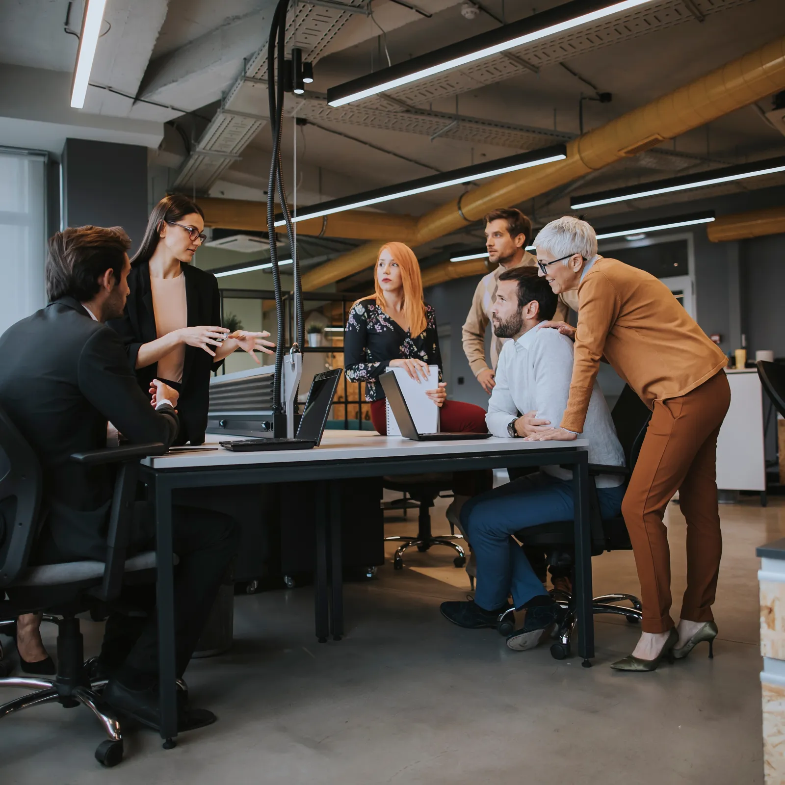 A diverse group of professionals collaborating at a modern office workspace.