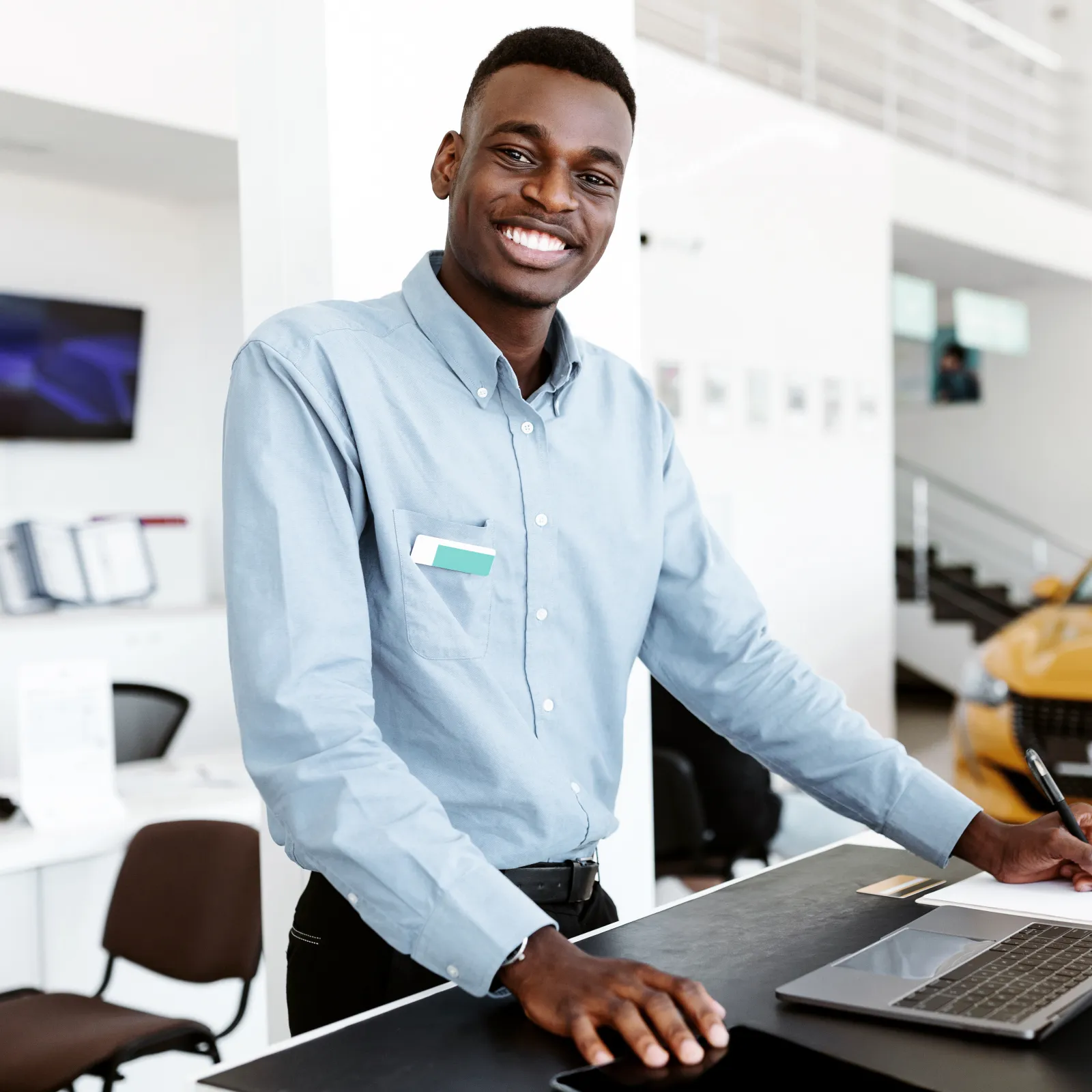 a man smiling and working on a laptop