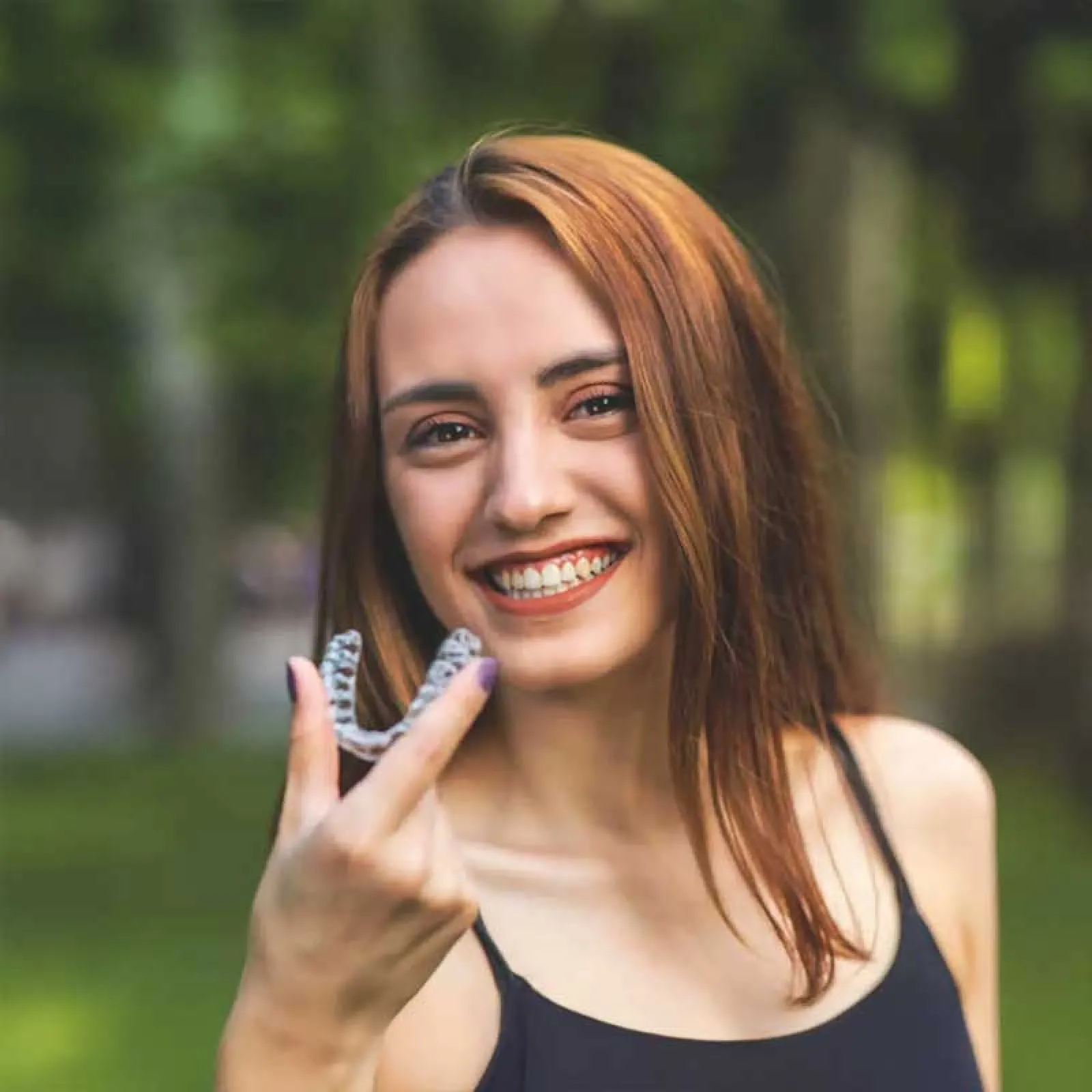 a woman smiling while holding a phone