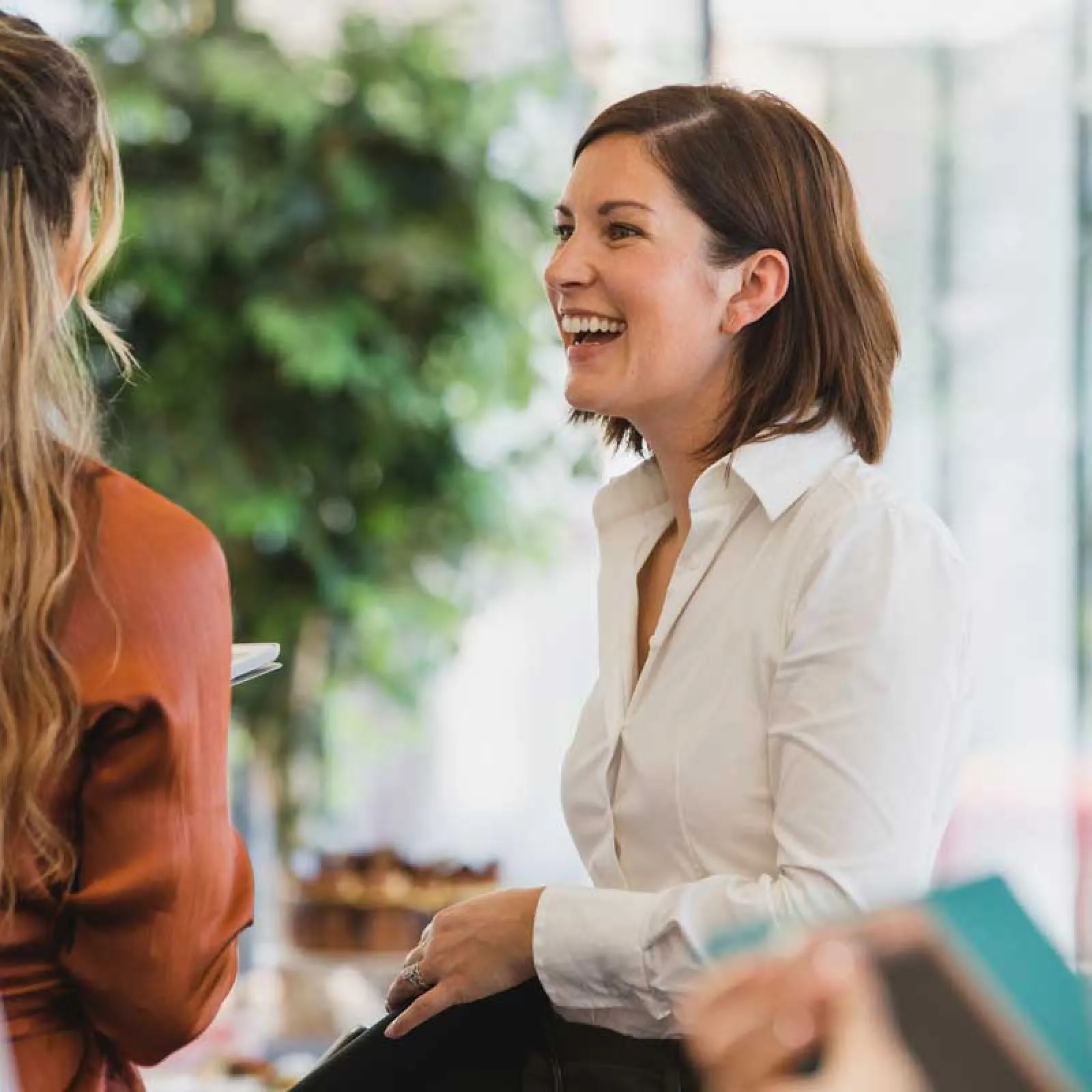 a person smiling and talking to another woman