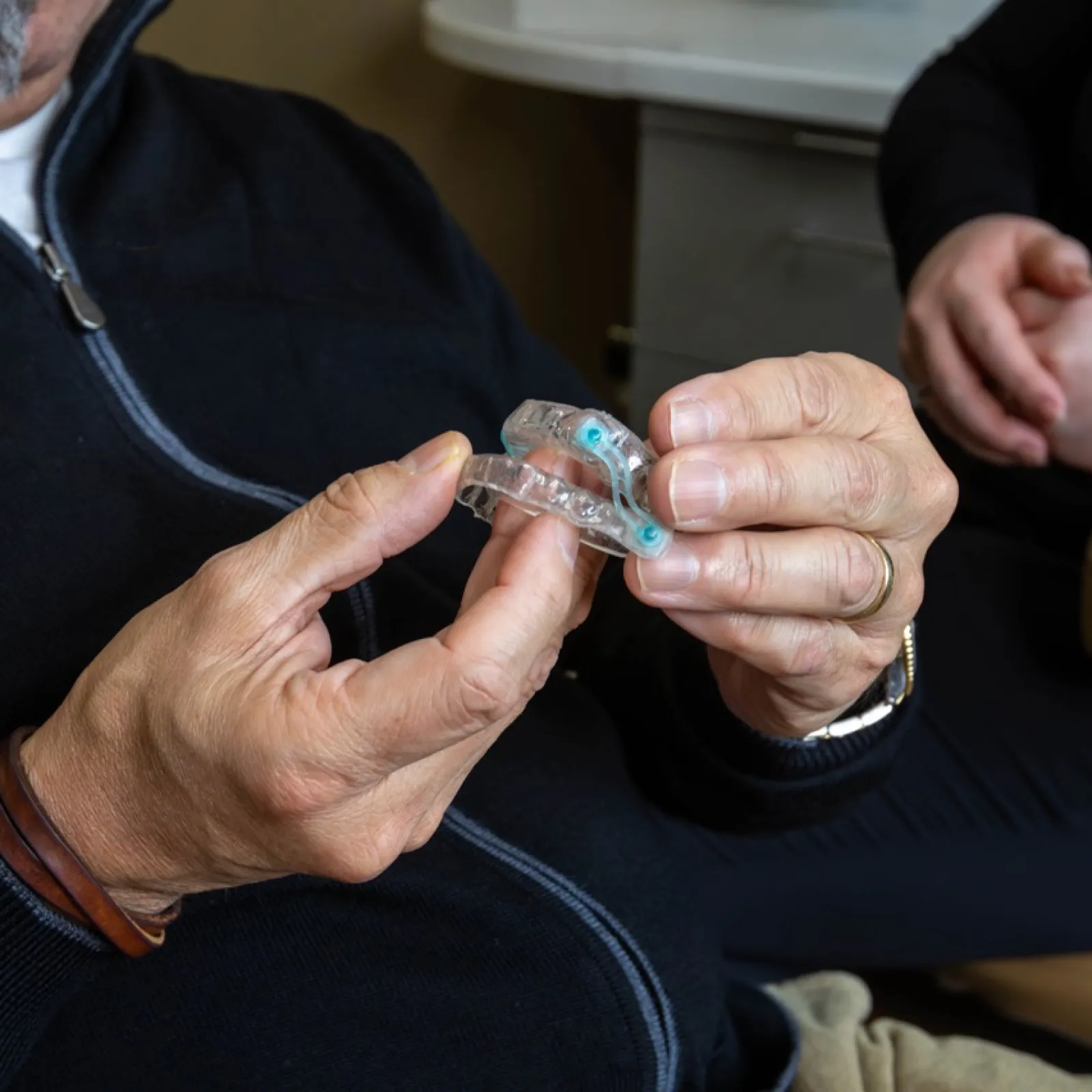 Person holding a clear dental night guard for teeth protection and alignment.