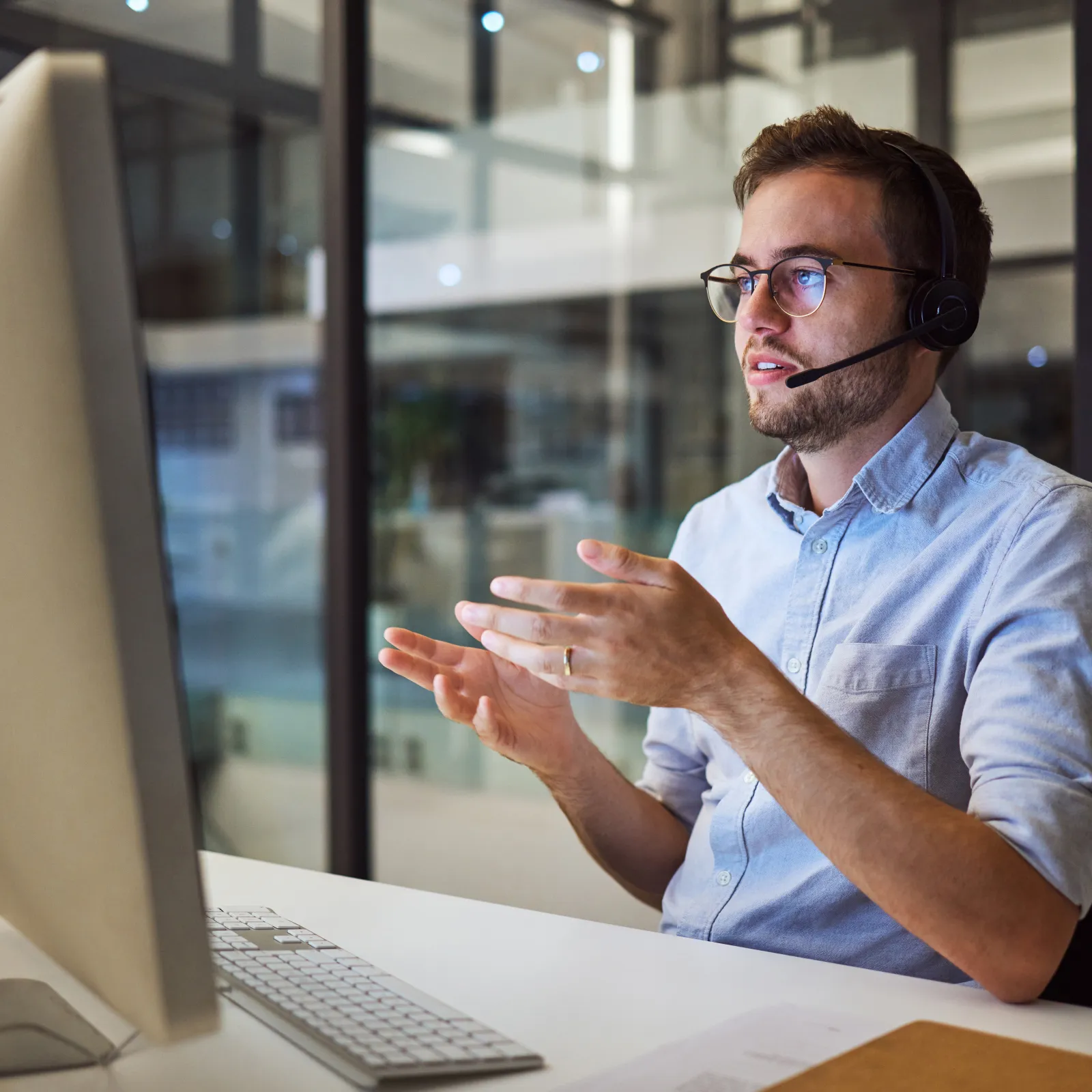 Focused call center agents wearing headsets working on computers in a modern office environment.