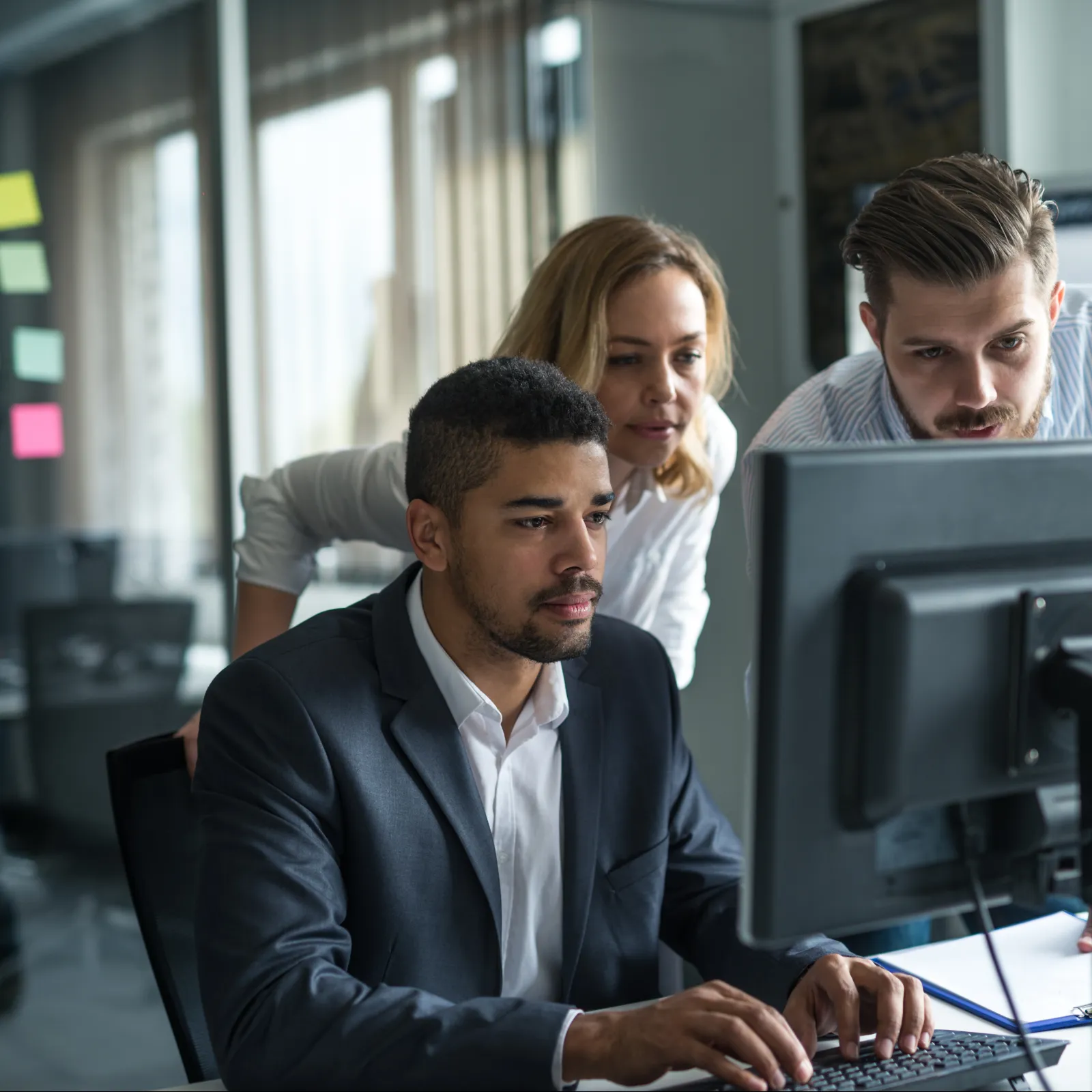 a group of people looking at a computer screen