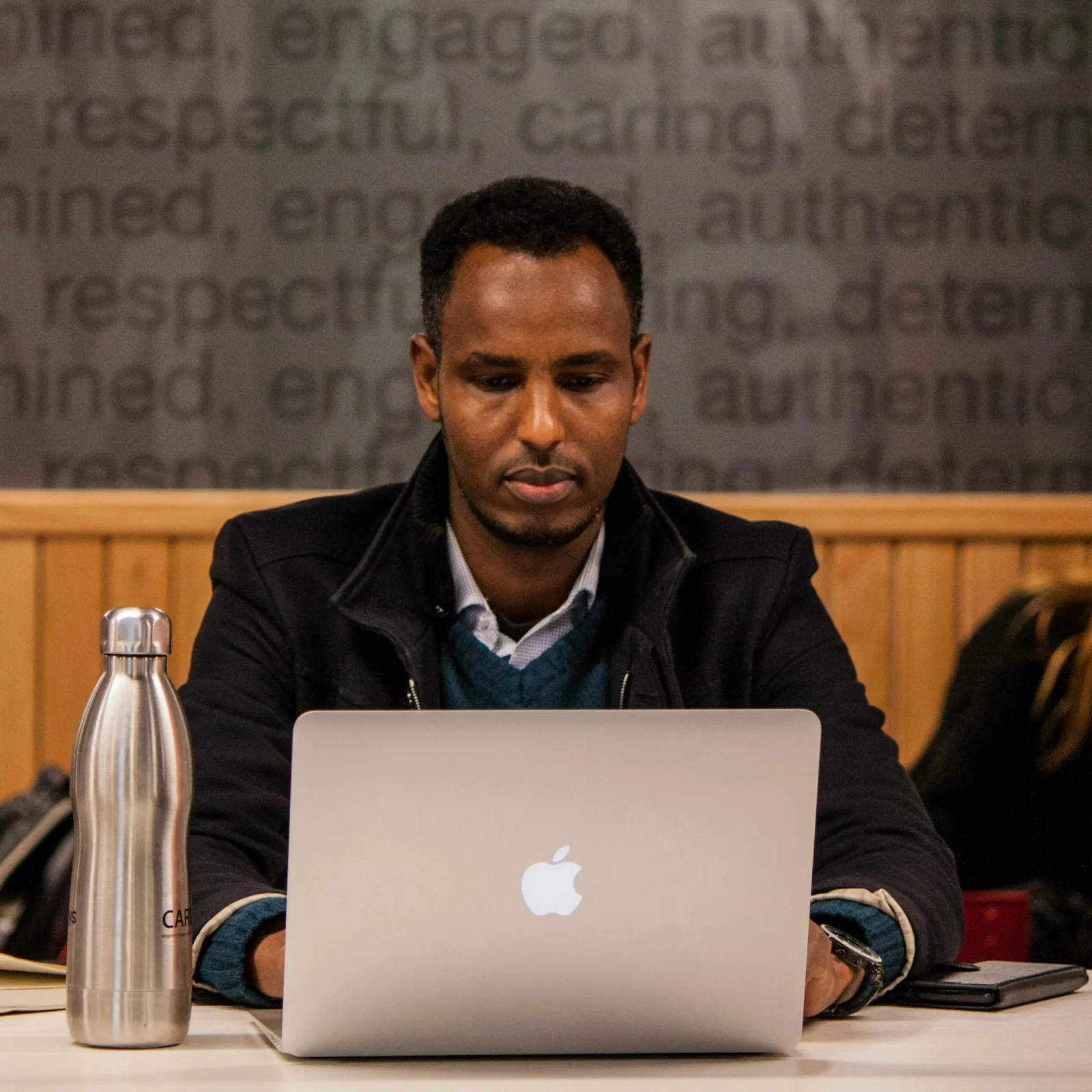 a man sitting at a table with a laptop