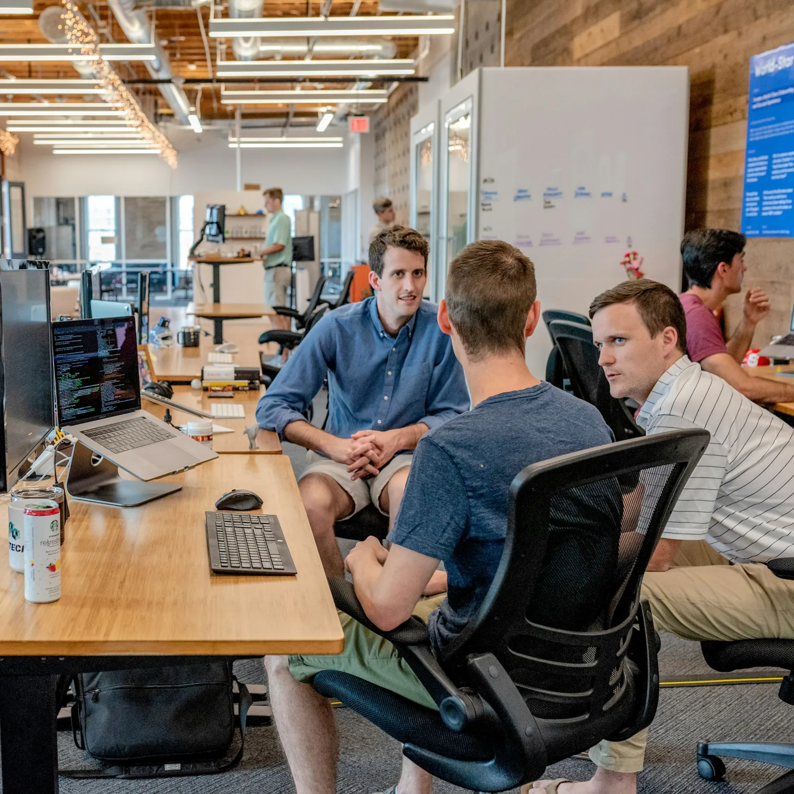 a group of people sitting at a table with computers