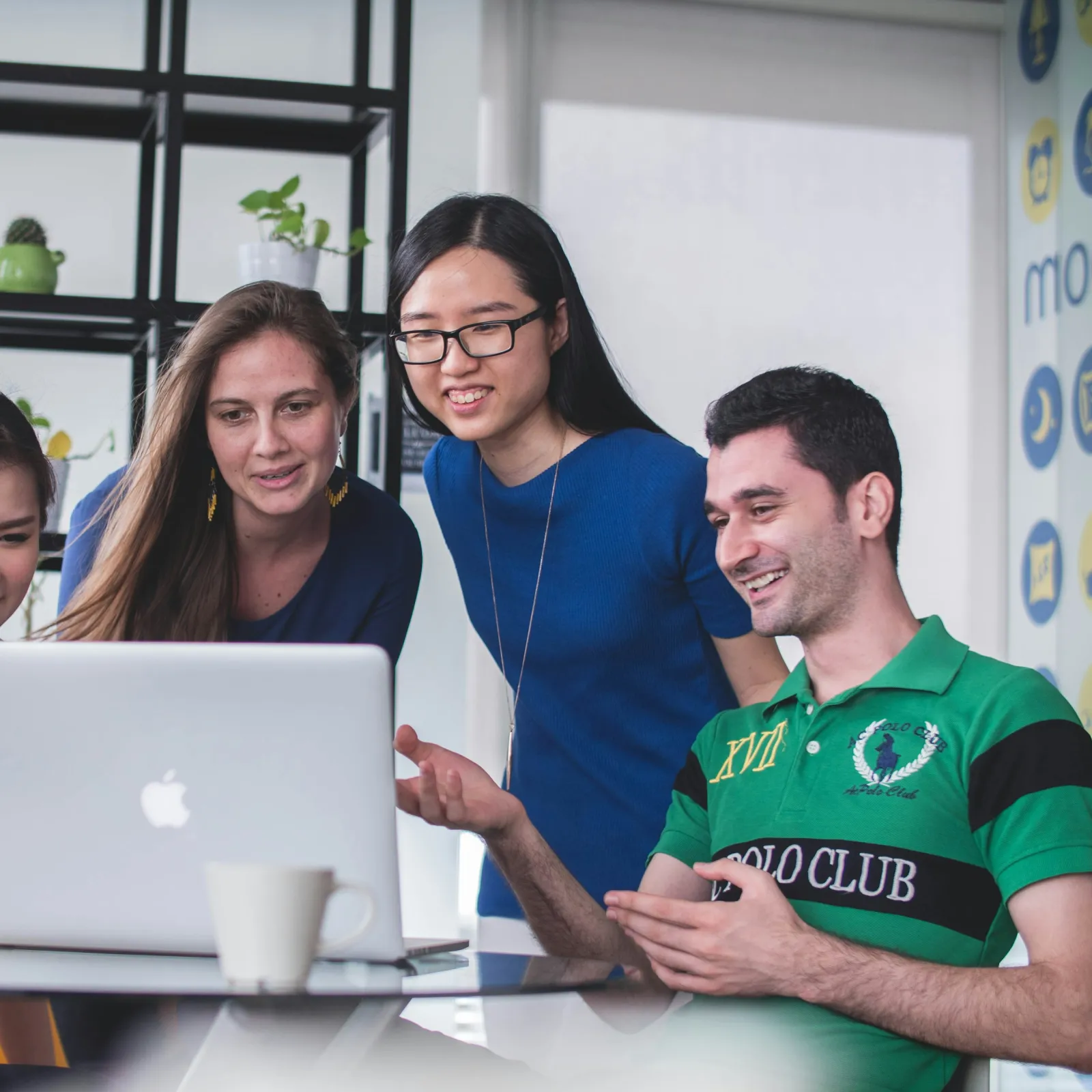 a group of people looking at a laptop