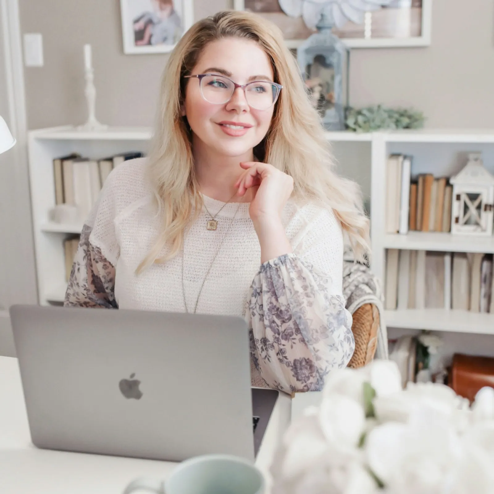 a woman sitting at a table with a laptop