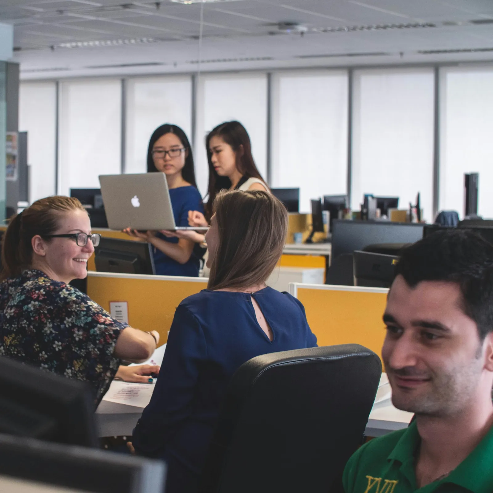 a group of people sitting at desks in a room