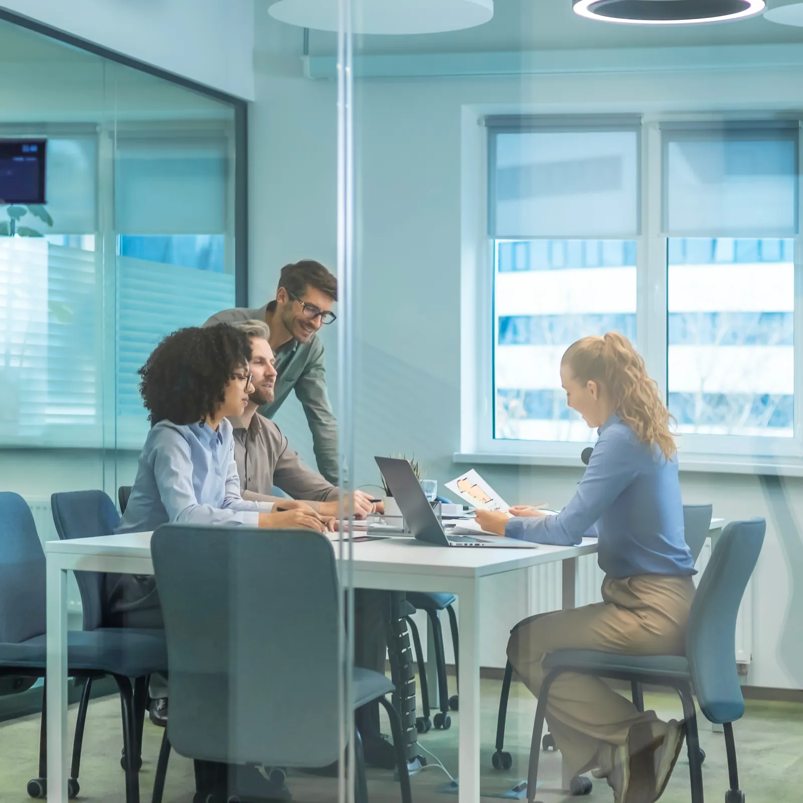 a group of people sitting at a table looking at a laptop
