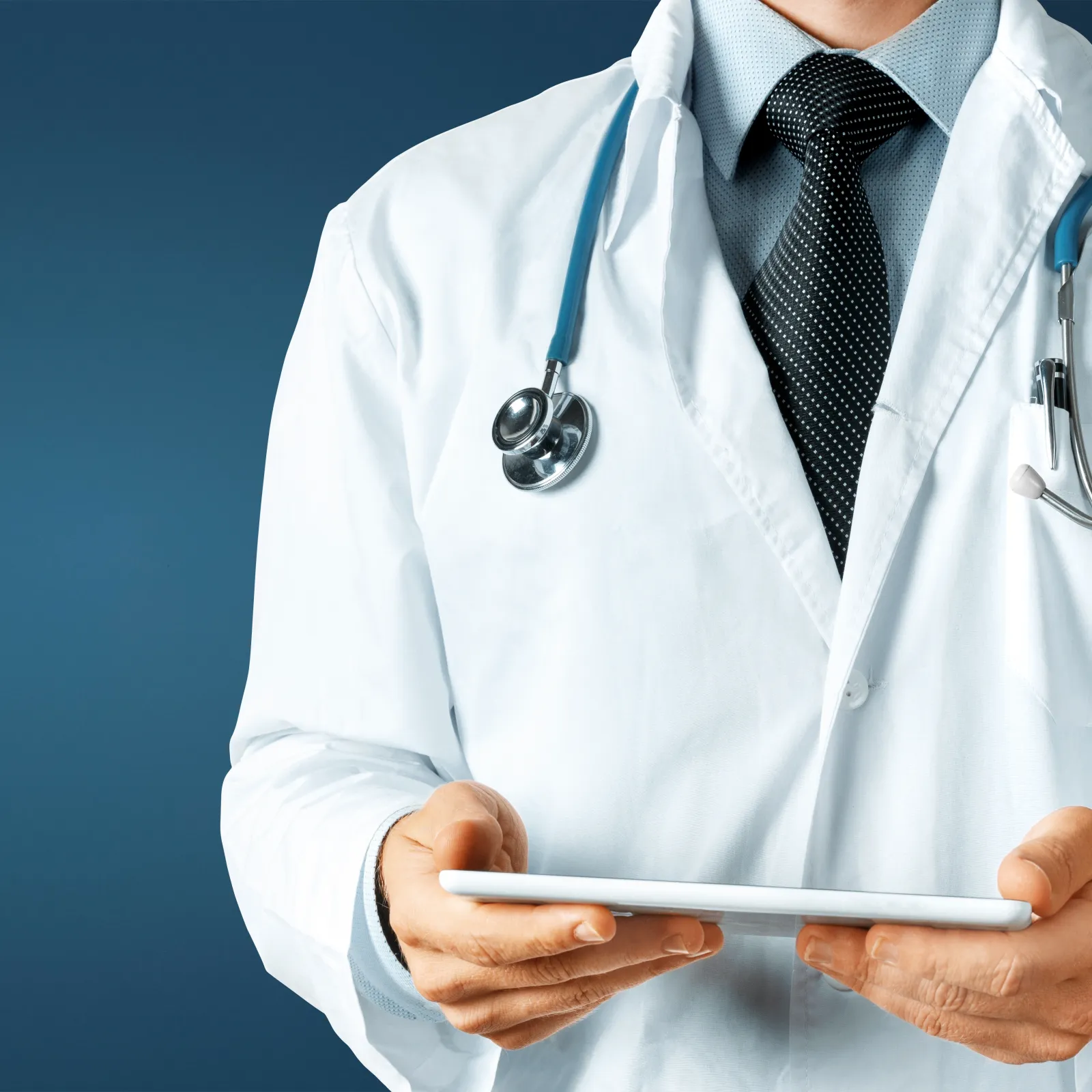 A doctor in a white coat holding a tablet, with a stethoscope around their neck against a blue background.