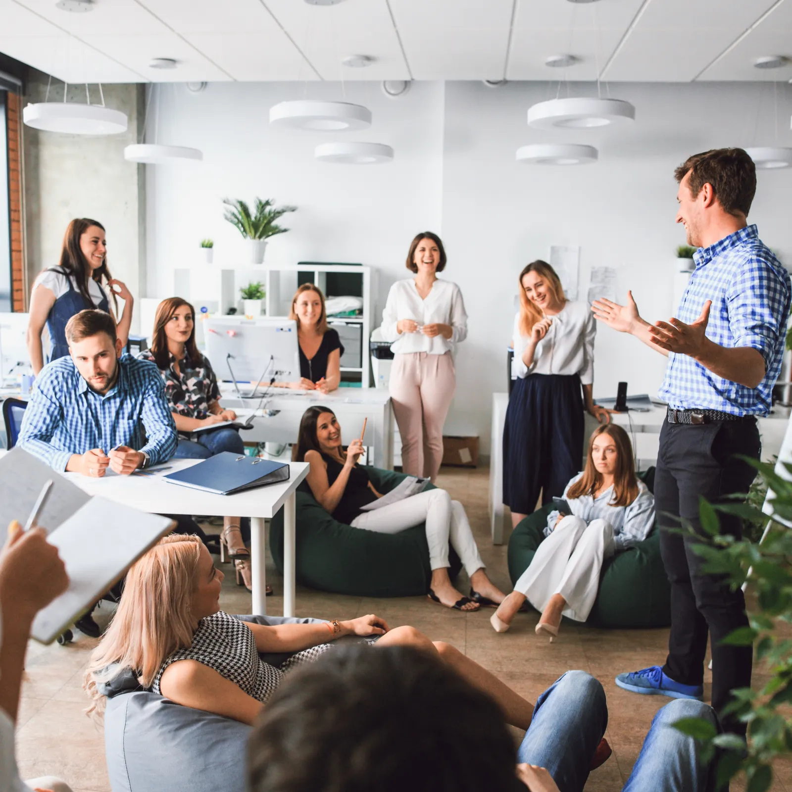 A team meeting in a modern office with engaged participants and a speaker presenting ideas.