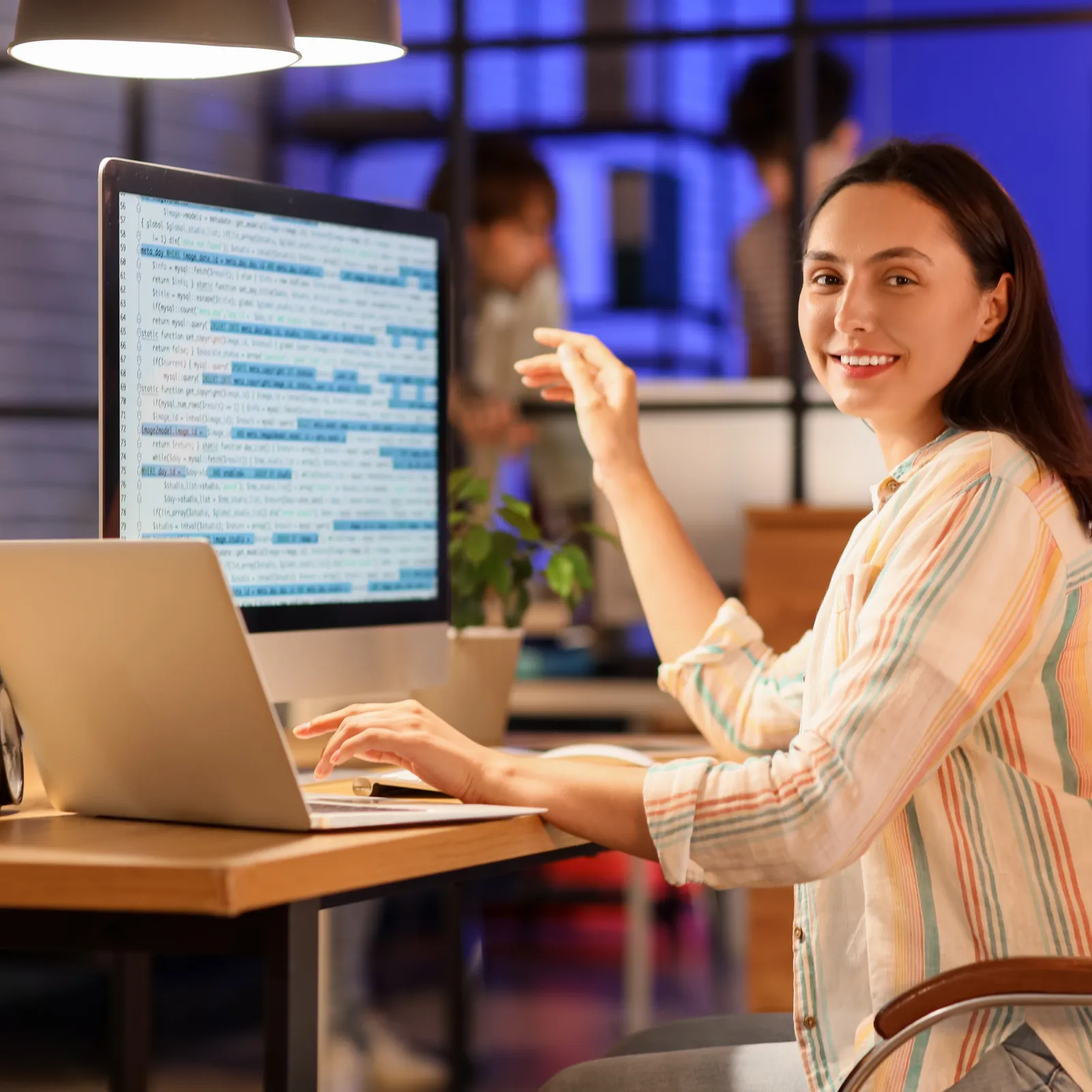 a woman sitting at a table with a laptop