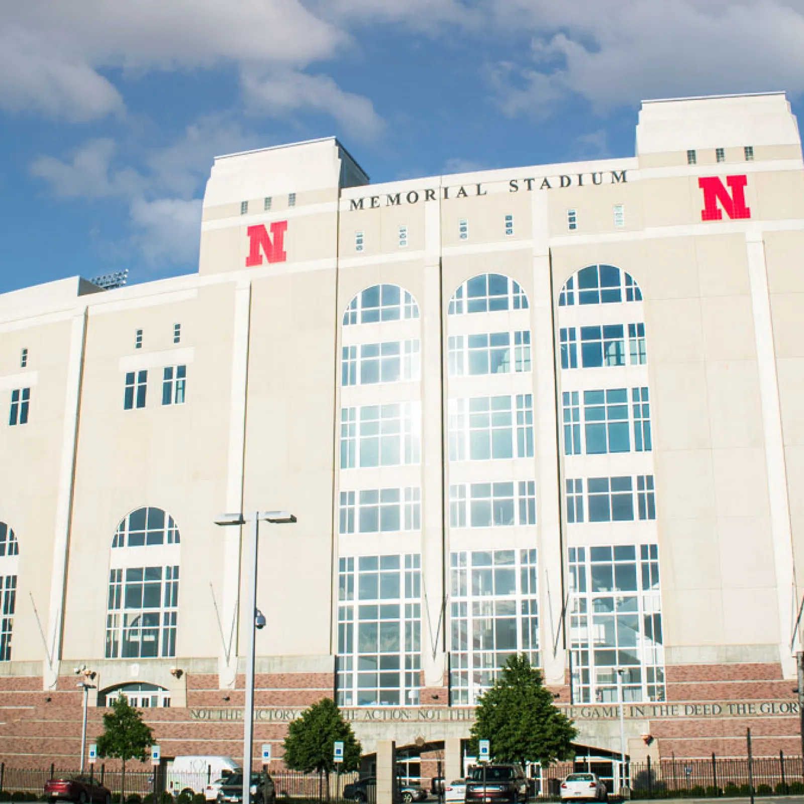 a large white building with a flag on top with Memorial Stadium in the background