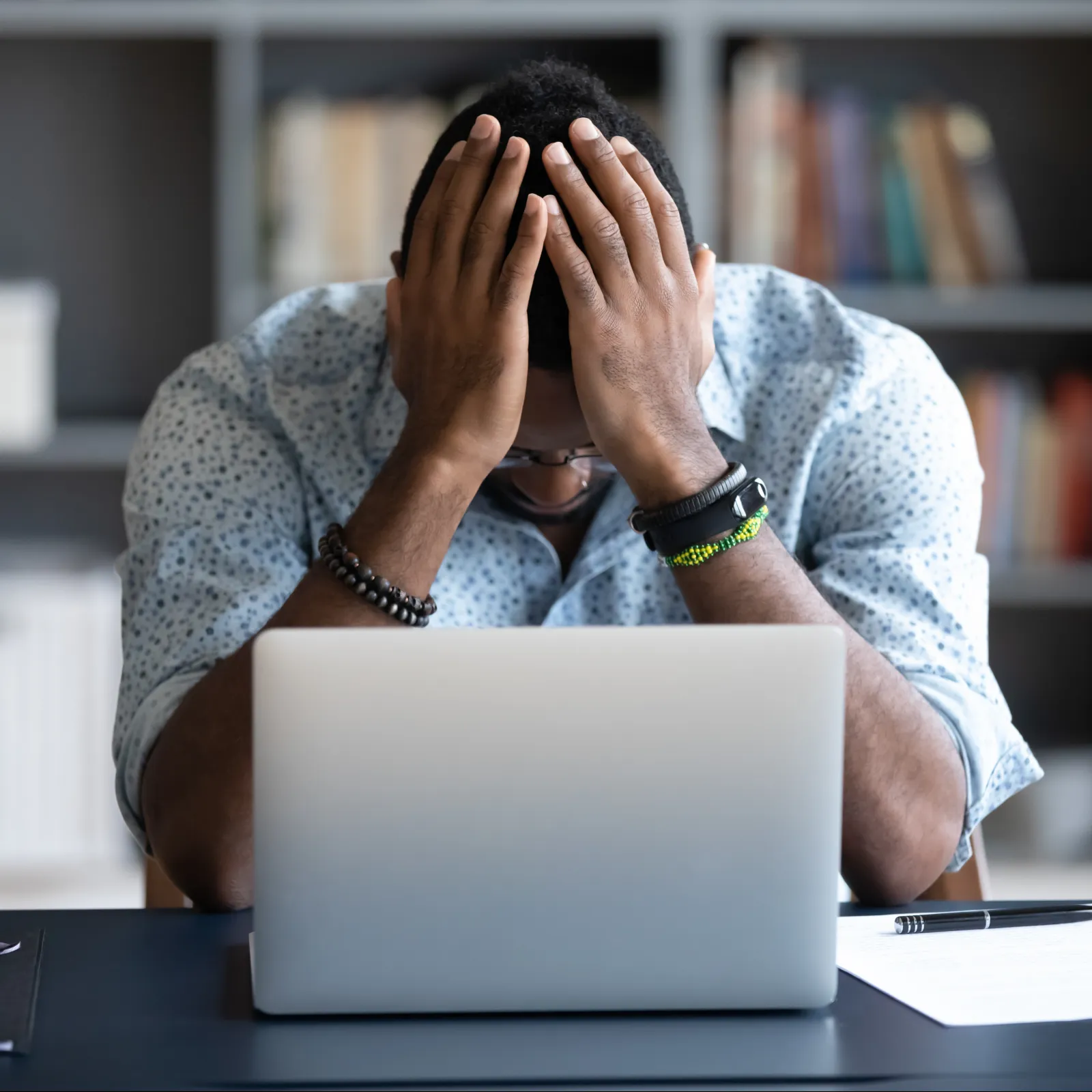 a person with the hands on the face in front of a laptop