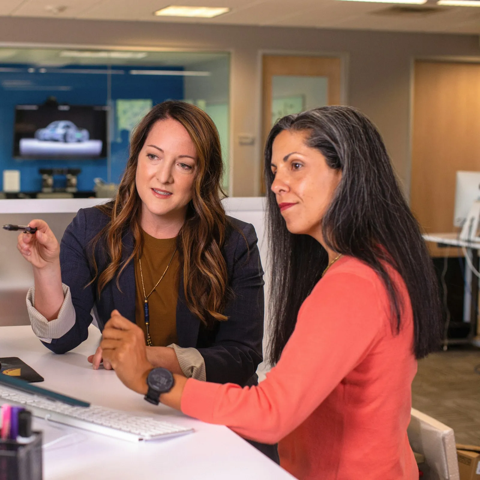 a couple of women looking at a computer screen