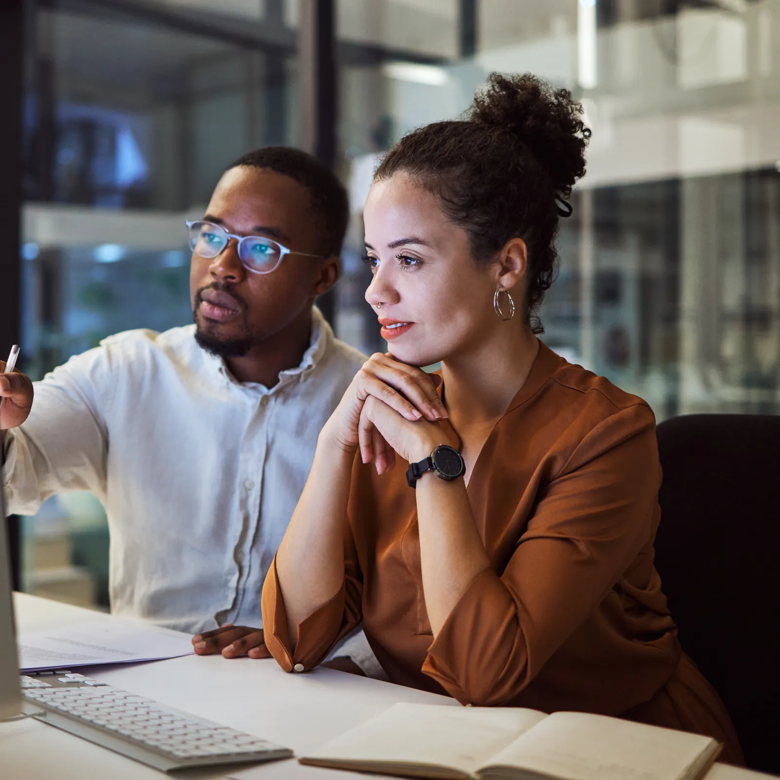 a man and a woman looking at a computer screen