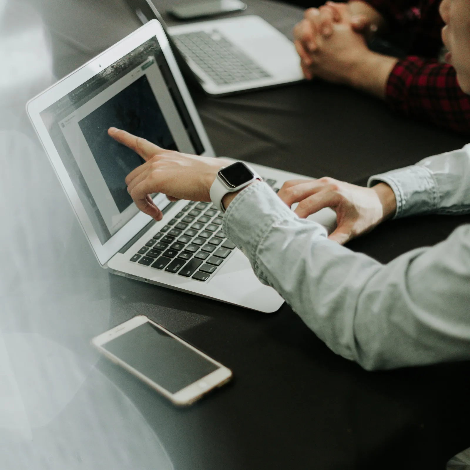 a man and a woman sitting at a table with laptops