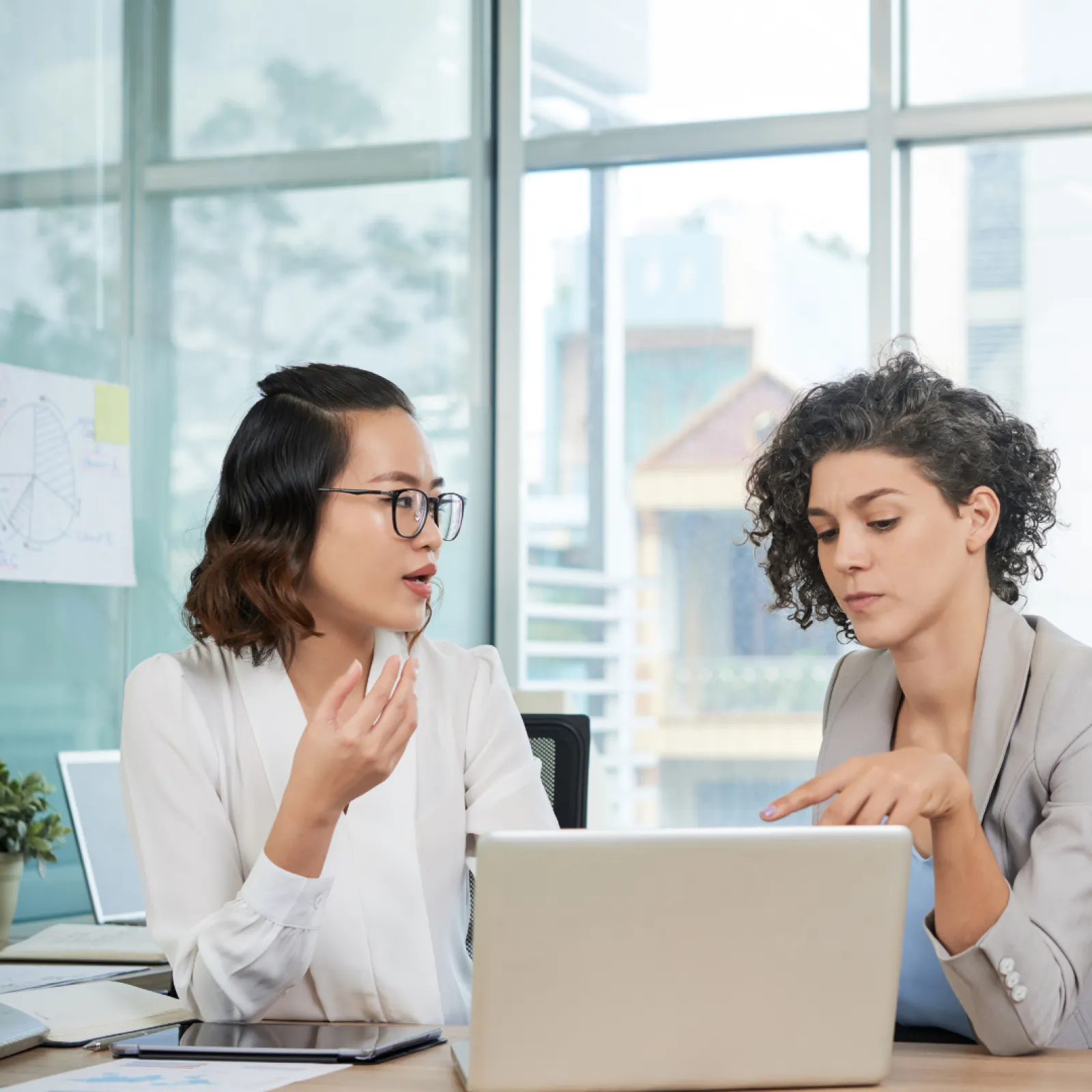 a woman and a man looking at a laptop