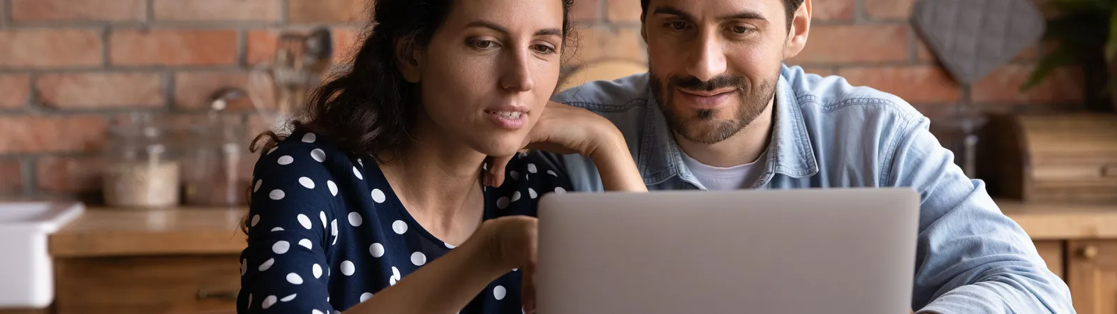 a man and a woman looking at a laptop