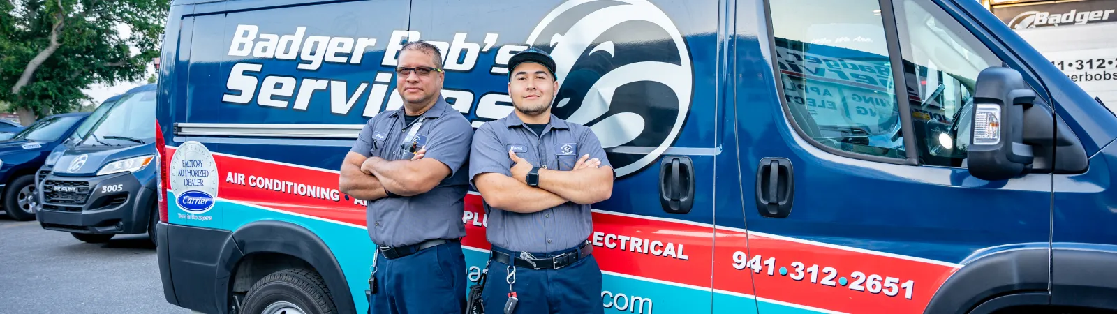 a couple of men standing in front of a blue and white truck