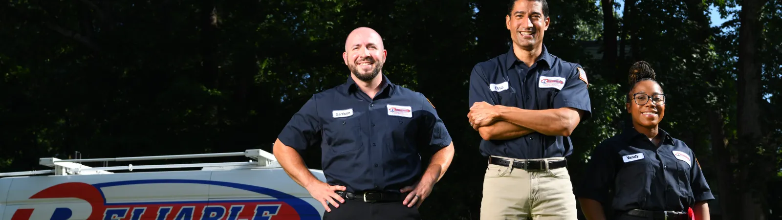 a group of air conditioning technicians standing next to a service van