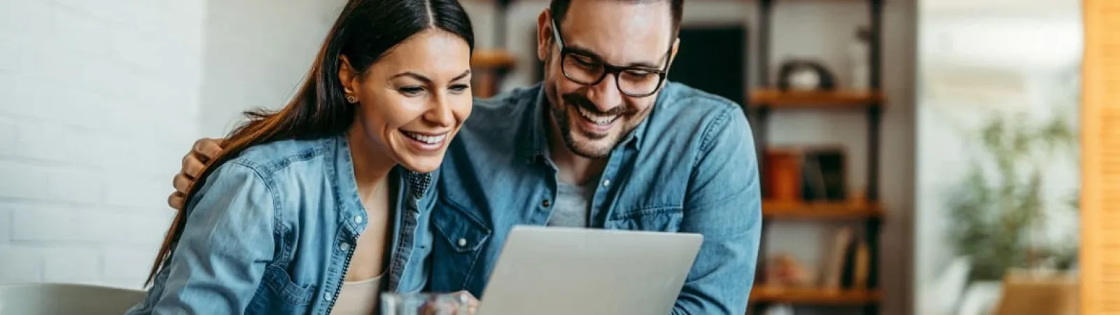 a man and a woman looking at a laptop