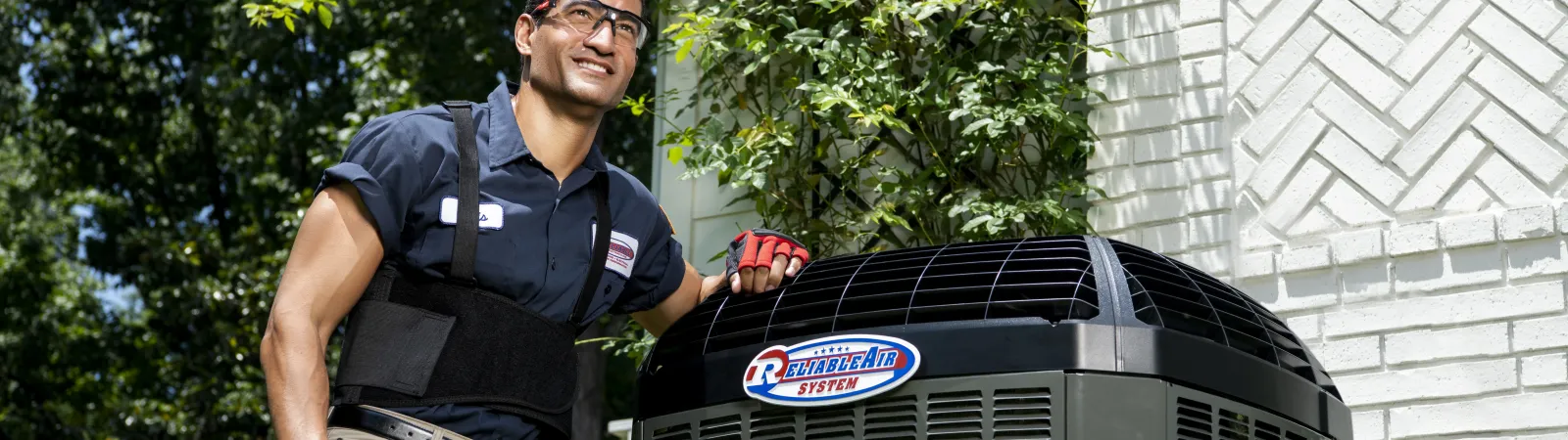 A technician stands proudly next to a modern air conditioning unit, showcasing expertise and professionalism.