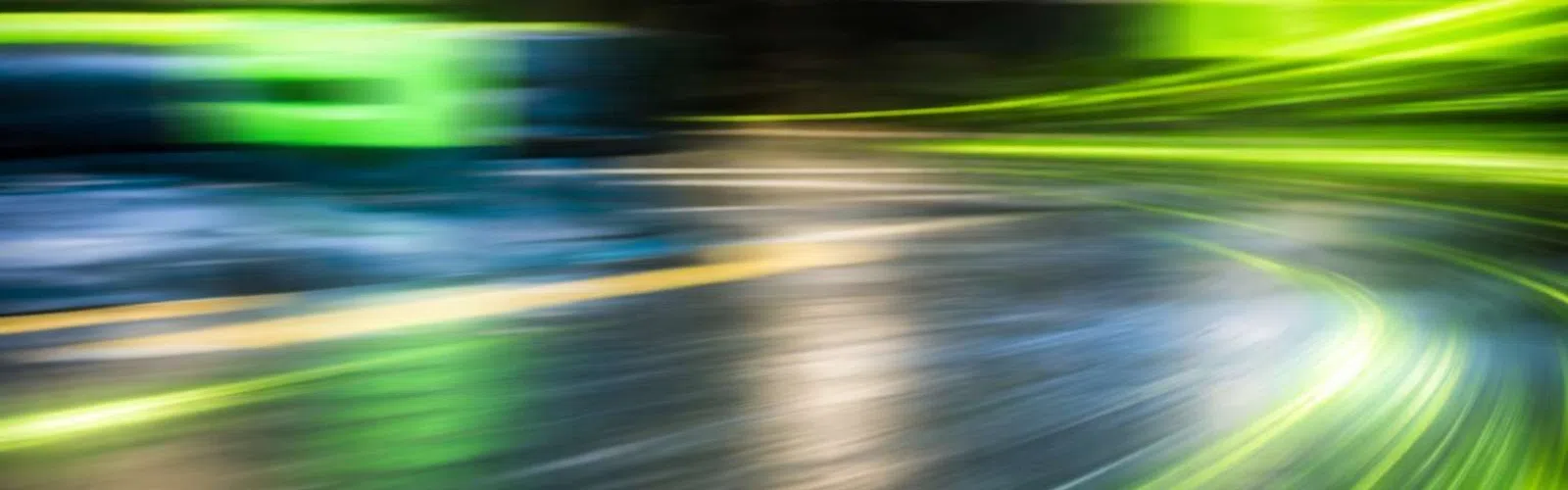 Dynamic abstract image with vibrant green and blue light streaks creating a sense of motion and speed.