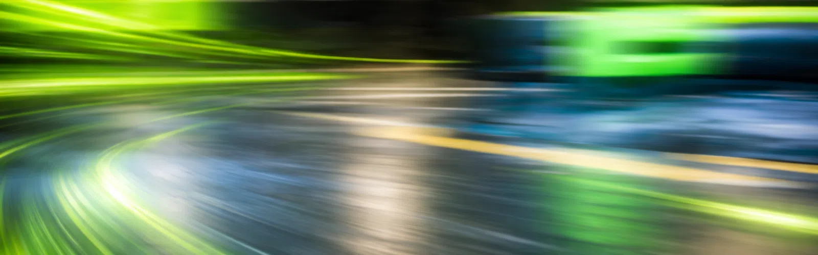 Abstract motion blur with vibrant green and blue streaks on a shiny curved surface creating a dynamic effect